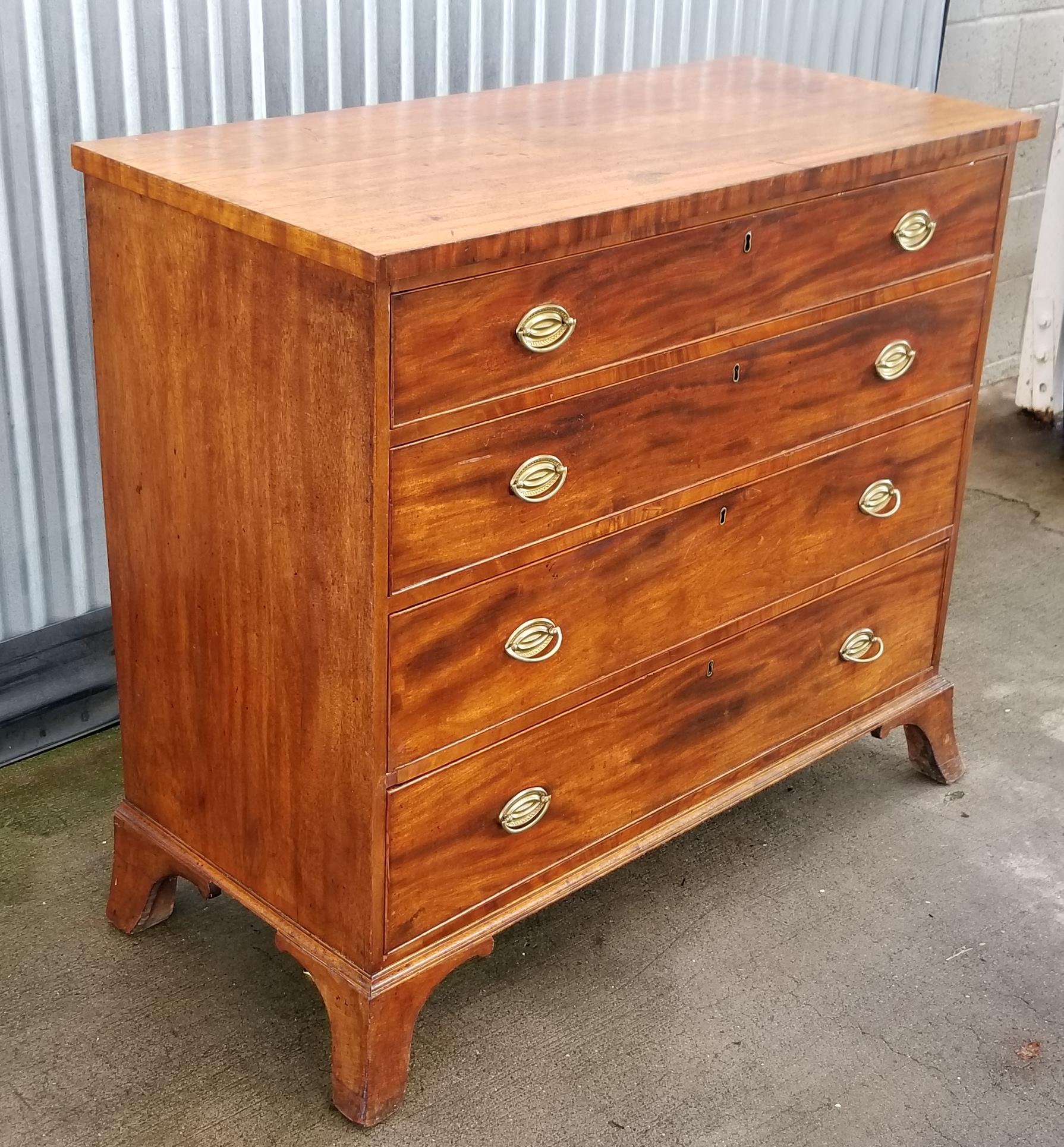 Period American Hepplewhite dresser in figured mahogany with original brass pulls. Four graduating drawers resting on original four French spayed feet, circa 1790-1820.