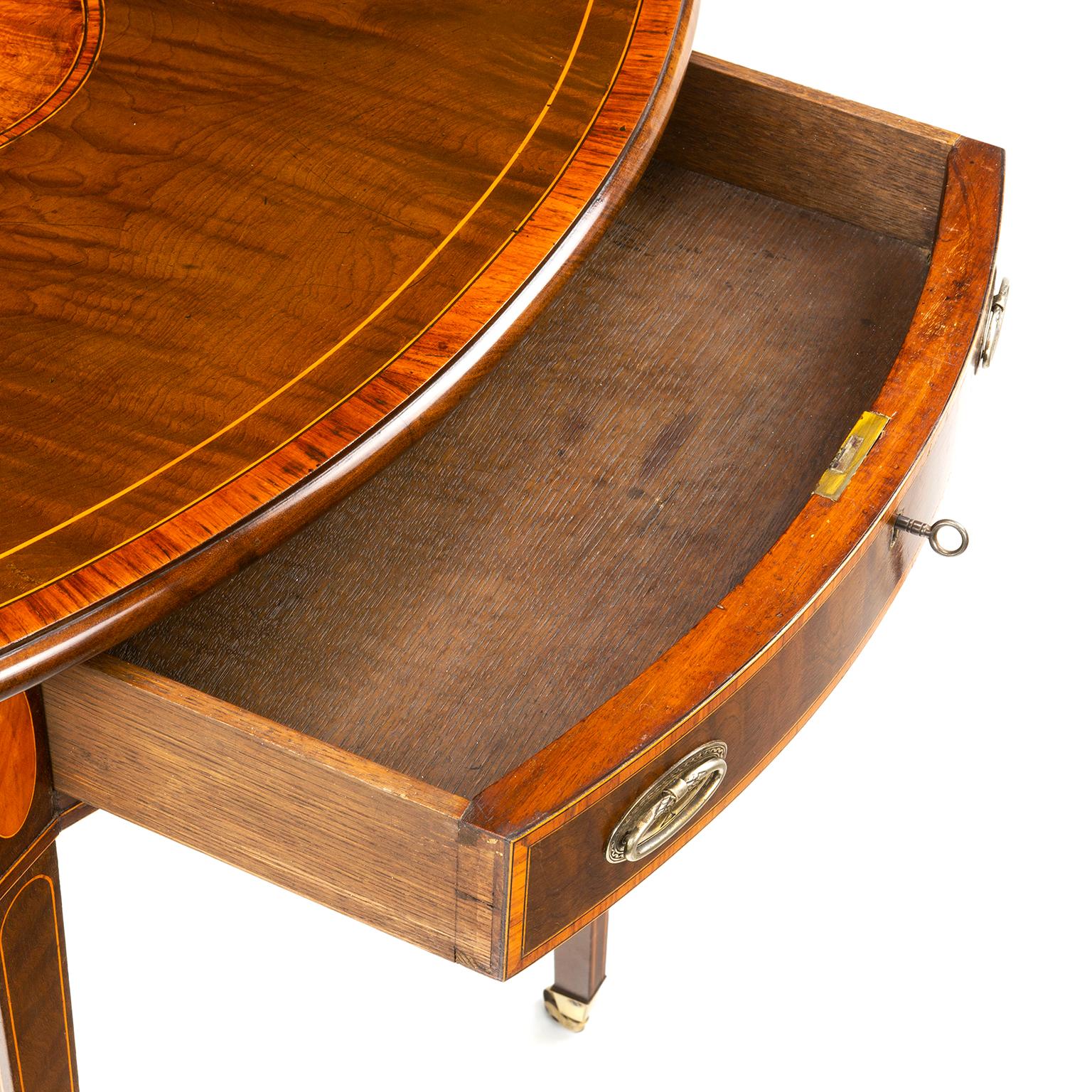 A George III Hepplewhite, inlaid sycamore veneered and inlaid oval Pembroke table, crossbanded in satinwood and tulipwood, bordered with boxwood and ebony lines, the hinged top with central oval burr walnut veneered panel, having a moulded edge,
