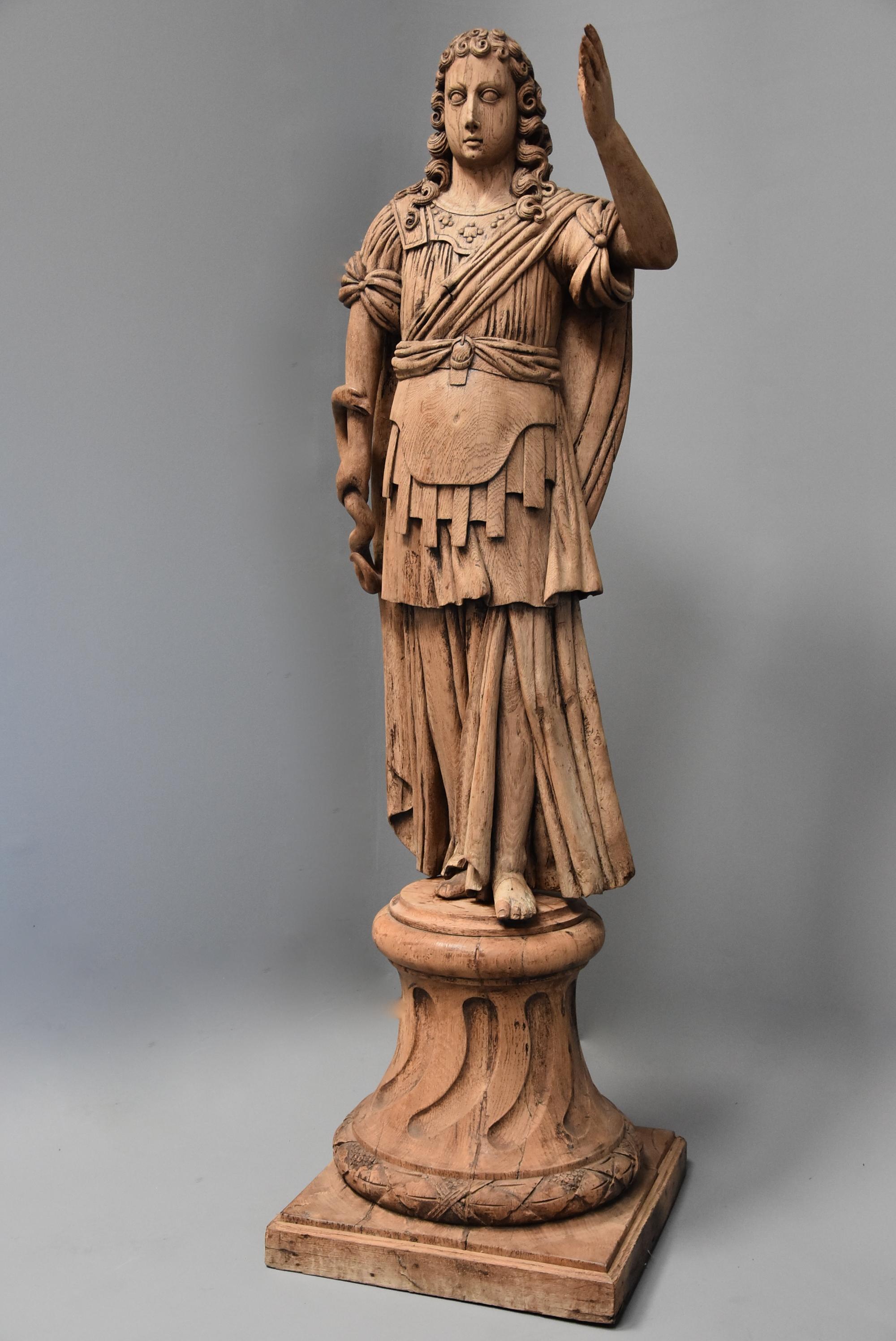 A large highly decorative 18th century Continental life-size carved oak figure of possibly the Greek God of Medicine, Asclepius.

This figure consists of a life size oak carved figure (possibly originally polychromed), his long curly hair resting