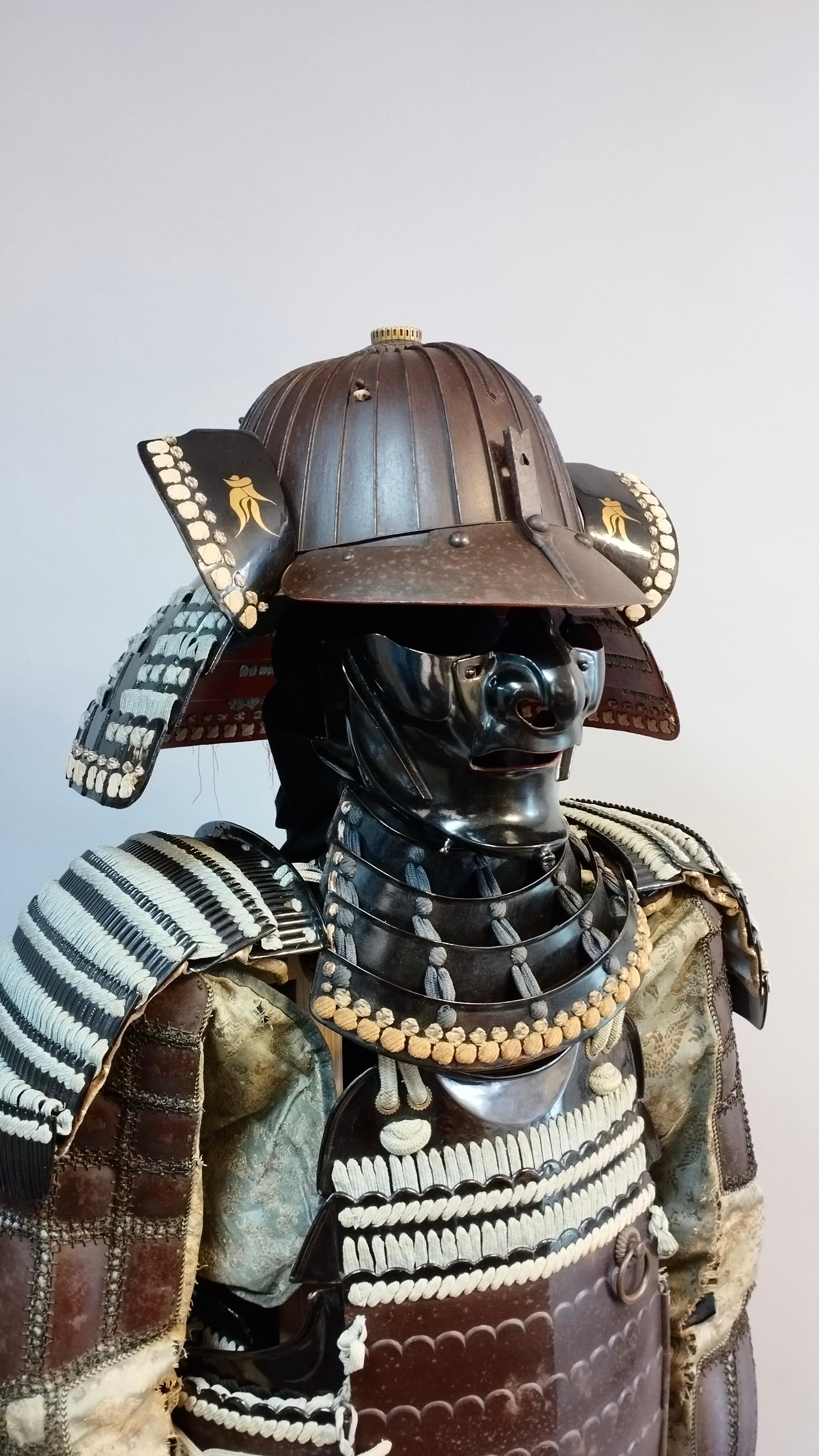 This is a truly exceptional set of 18th century Samurai armor that is sure to impress any collector or enthusiast. The patinated iron used in its construction has aged beautifully, giving the armor a truly unique appearance that is sure to catch the