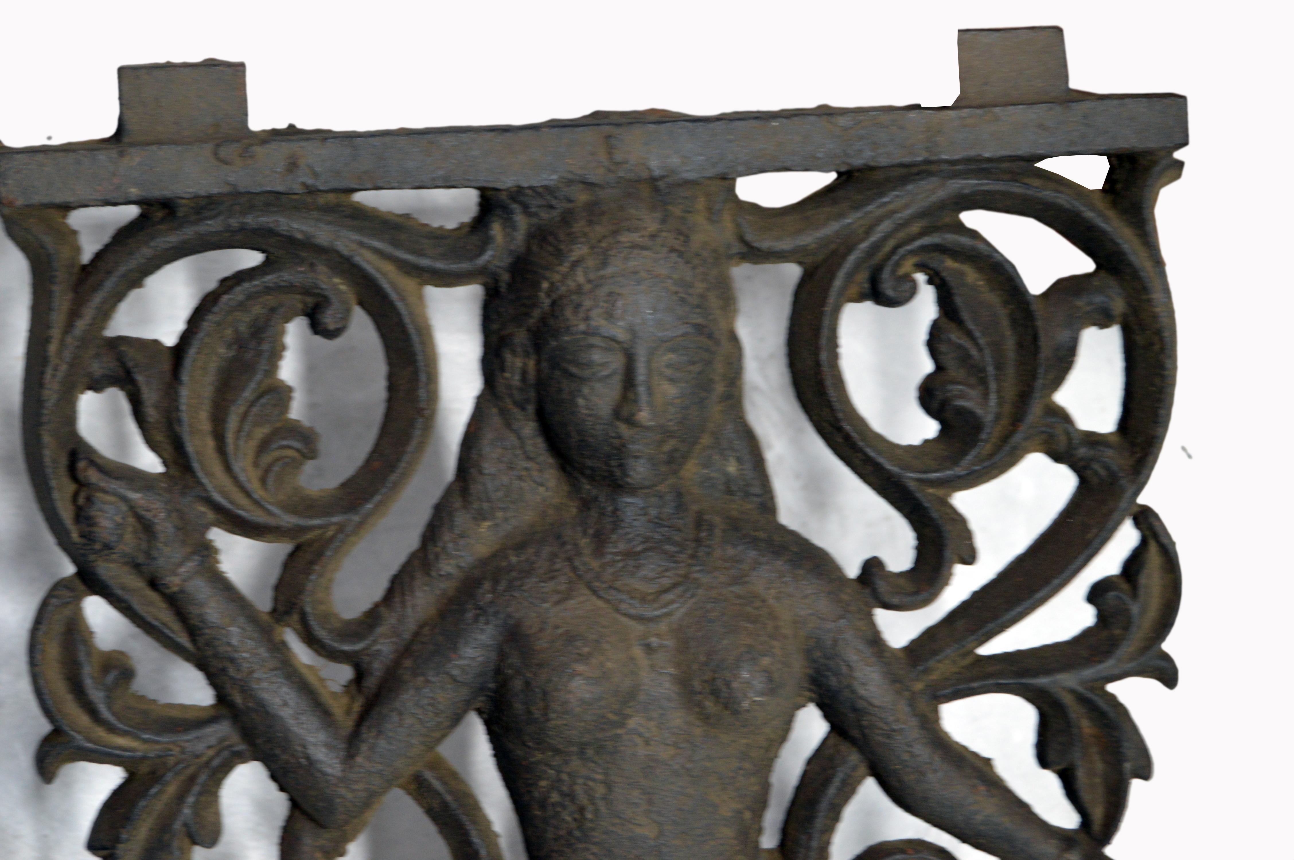 An 18th century iron plaque cast as a window gate for a temple with fretwork and female figure. The fretwork foliage background on this piece focuses attention on a standing naked female character wearing a fabric wrap, shoes, a necklace and