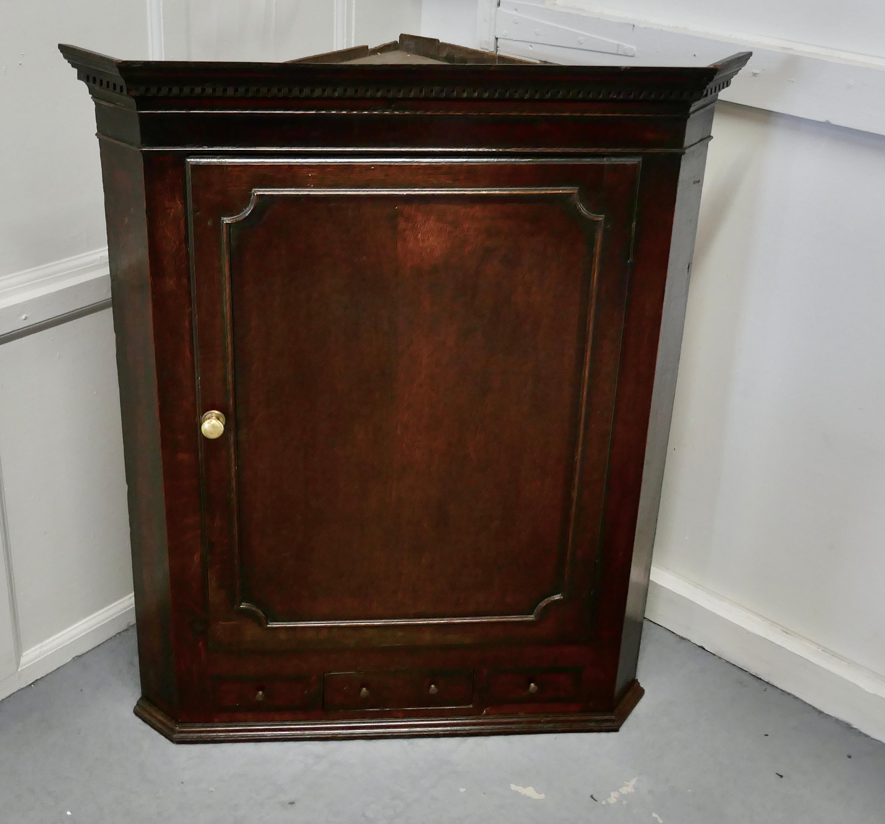 18th century inlaid country oak corner cupboard

18th century corner cupboard made in country oak, it has a panel door enclosing 3 shaped corner shelves, the original paper lining is still present and has a good bright colour
At the bottom there