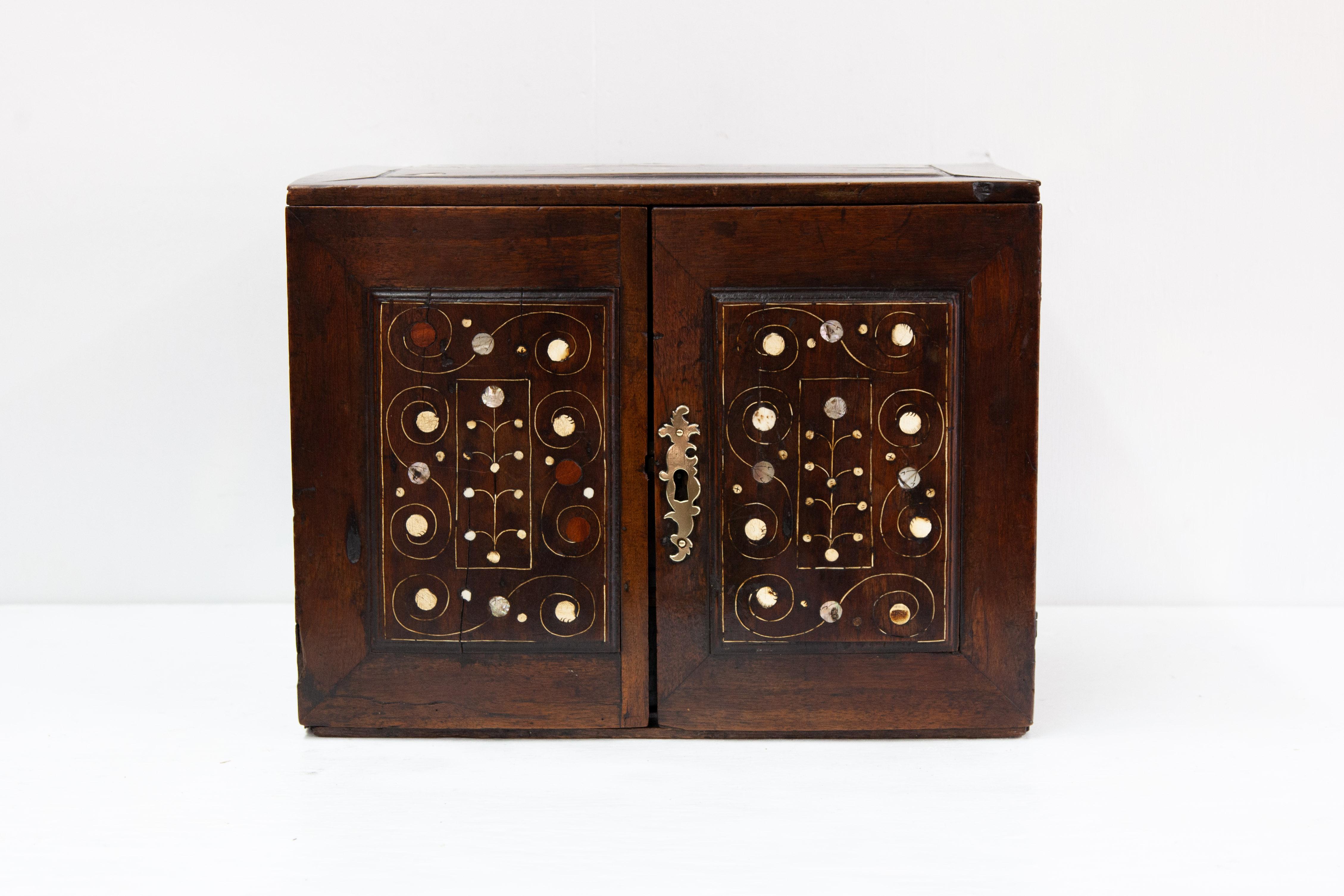 Einbauschrank aus Nussbaum mit Intarsien aus dem 18. Jahrhundert, Deckel, Vorderseite und Seiten mit eingelegten Paneelen mit skurrilen Intarsien, die gebänderten Innenschubladen mit Perlmuttintarsien.