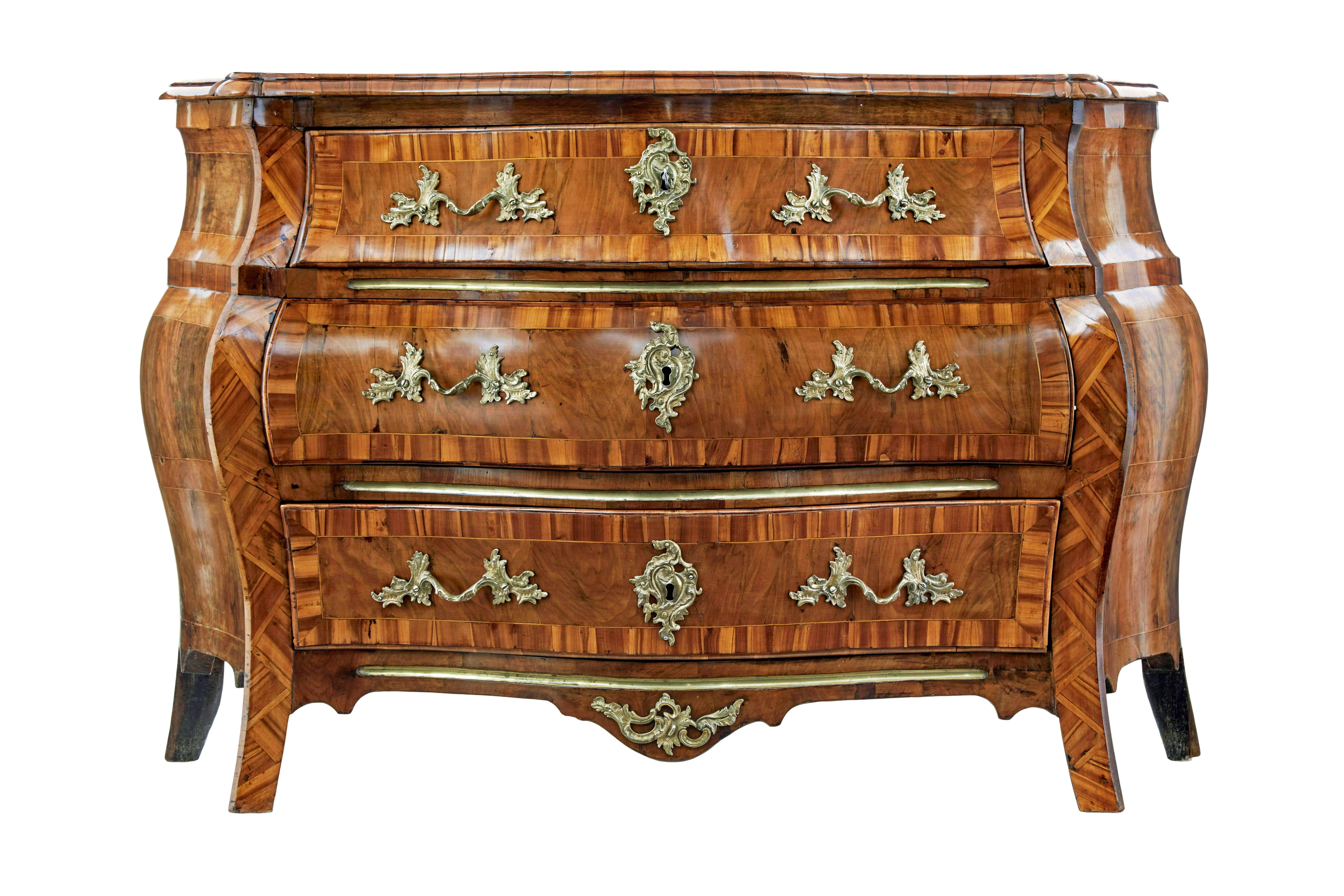 Commodo a bombe in noce intarsiato del XVIII secolo, circa 1790.

Commode svedese revival rococò di ottima qualità, con la tipica forma a bombe che si allarga al centro e si incurva alla base.

Piano superiore in noce sagomato con toppe che