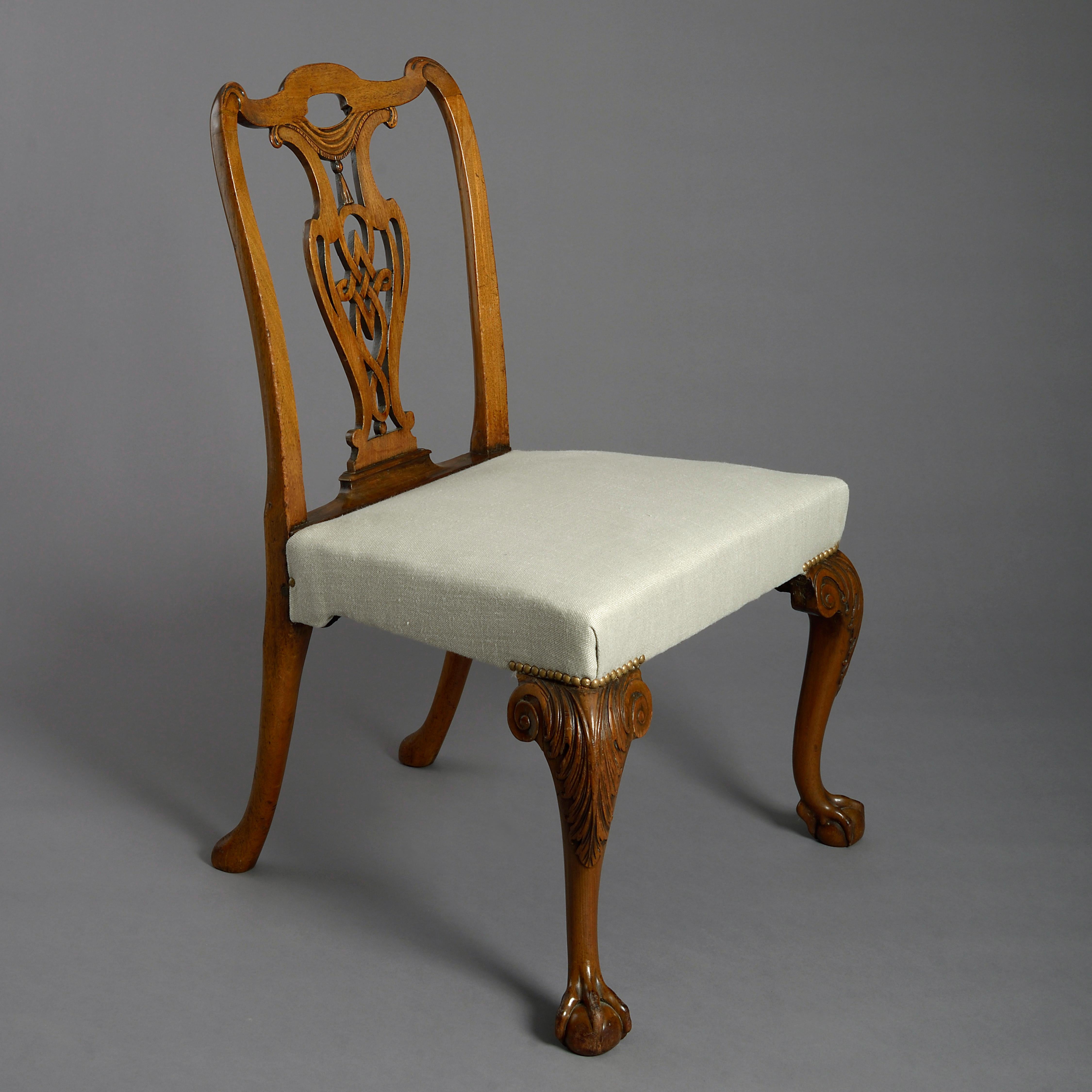 A fine and rare mid-18th century George II Period mahogany side chair, the back with shaped top rail above a pierced splat with carved drapes, a tassel and fretwork, the upholstered seat raised upon cabriole leg with acanthus carving, terminating in