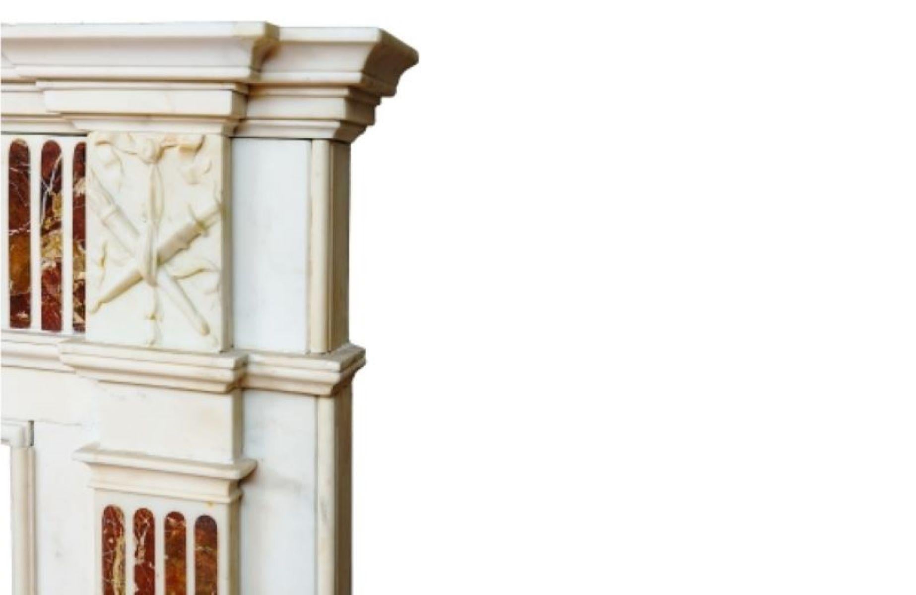 Marco de chimenea georgiano irlandés del siglo XVIII de mármol blanco estatuario con una placa central tallada con un diseño de urna de Adán y, a ambos lados, una pilastra rematada por un panel decorado con una antorcha y una espada. Incrustaciones
