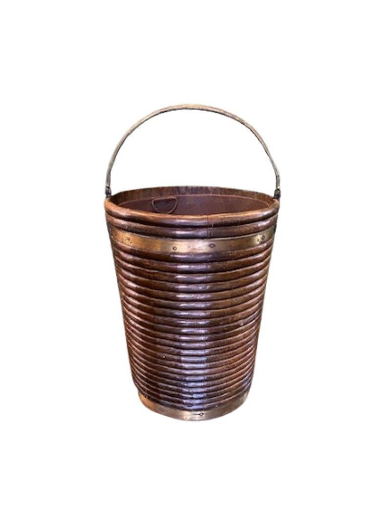 18th Century Irish Georgian Ribbed Peat Bucket, circa 1770s, a scarce large size and desirable form fire-side mahogany peat bucket with bold lathe-turned ribbing, brass bands and strong bail handle, with original fitted sheet iron liner. A very