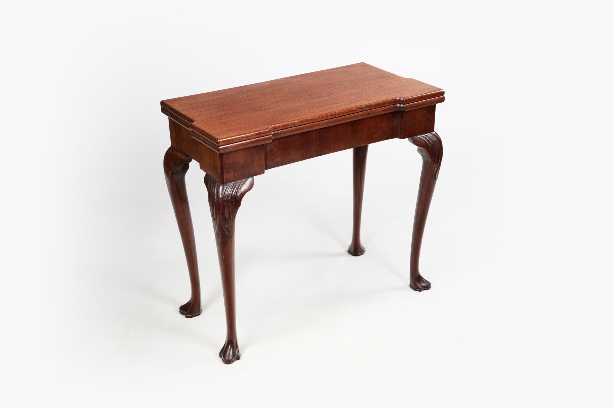 18th Century Irish mahogany games table with breakfront foldover top, cabriole legs terminating in trefoil feet & felt-lined surface on the Interior. To the rear are twin gatelegs with pad feet that pull out to support the open table.