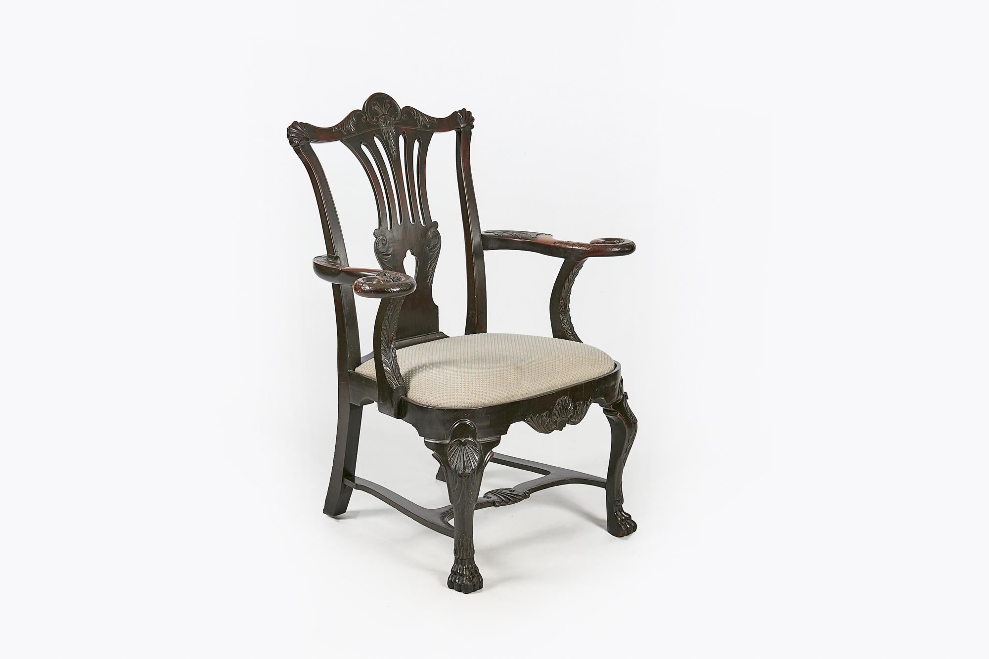 18th century Irish pair of Butler carver chairs, the bow shaped top rail with centred acanthus leaf and C scroll motif flanked with corners embellished with scallop shells raised over pierced splat with acanthus and C-scroll detail, the outscrolling