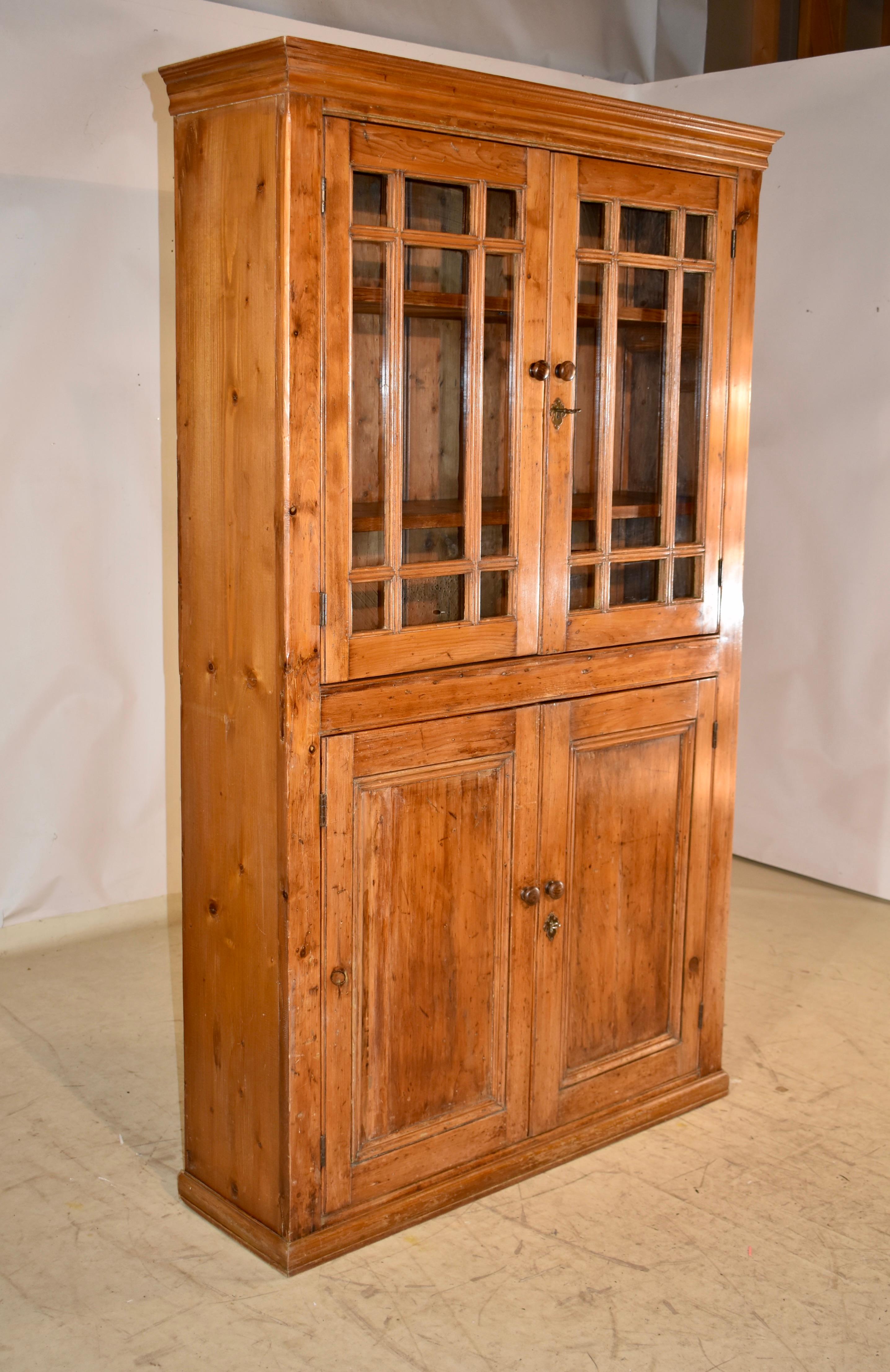 Wandschrank aus Kiefernholz aus dem späten 18. Jahrhundert in Irland.  Das Oberteil ist mit einer schönen Krone verziert, die in einfache Seiten und zwei verglaste Türen auf der Vorderseite mit geteilten Glasscheiben übergeht.  Die Türen lassen sich