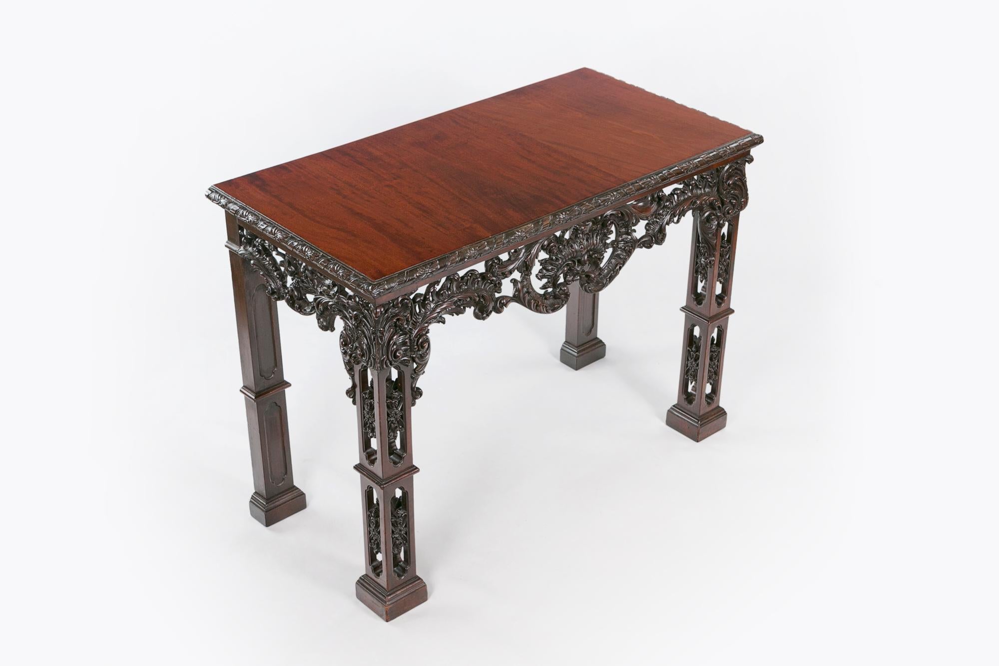 18th century Irish Chippendale mahogany side table of rectangular form, the moulded top with carved banding of flowerhead and ribbon motif raised over pierced apron with central stylised acanthus fan flanked with scrolling acanthus and scroll motif