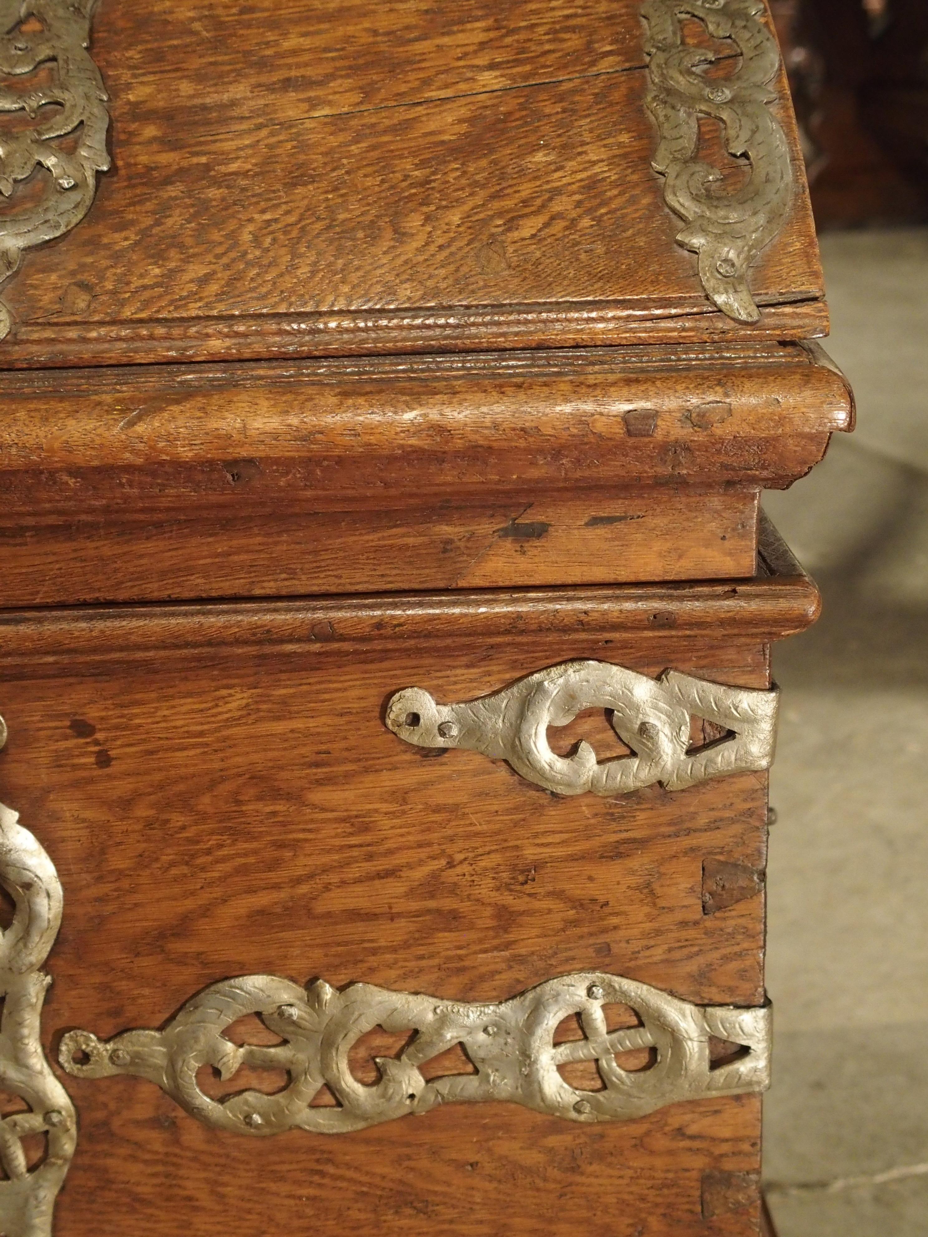 Diese hübsche Truhe aus Eichenholz im Barockstil hat einen gewölbten Deckel und skurrile Beschläge aus patiniertem Eisen. Die Truhe wurde in den 1700er Jahren (möglicherweise 1757) angefertigt. Diese Art von gewölbten Eichenstämmen mit dekorativen