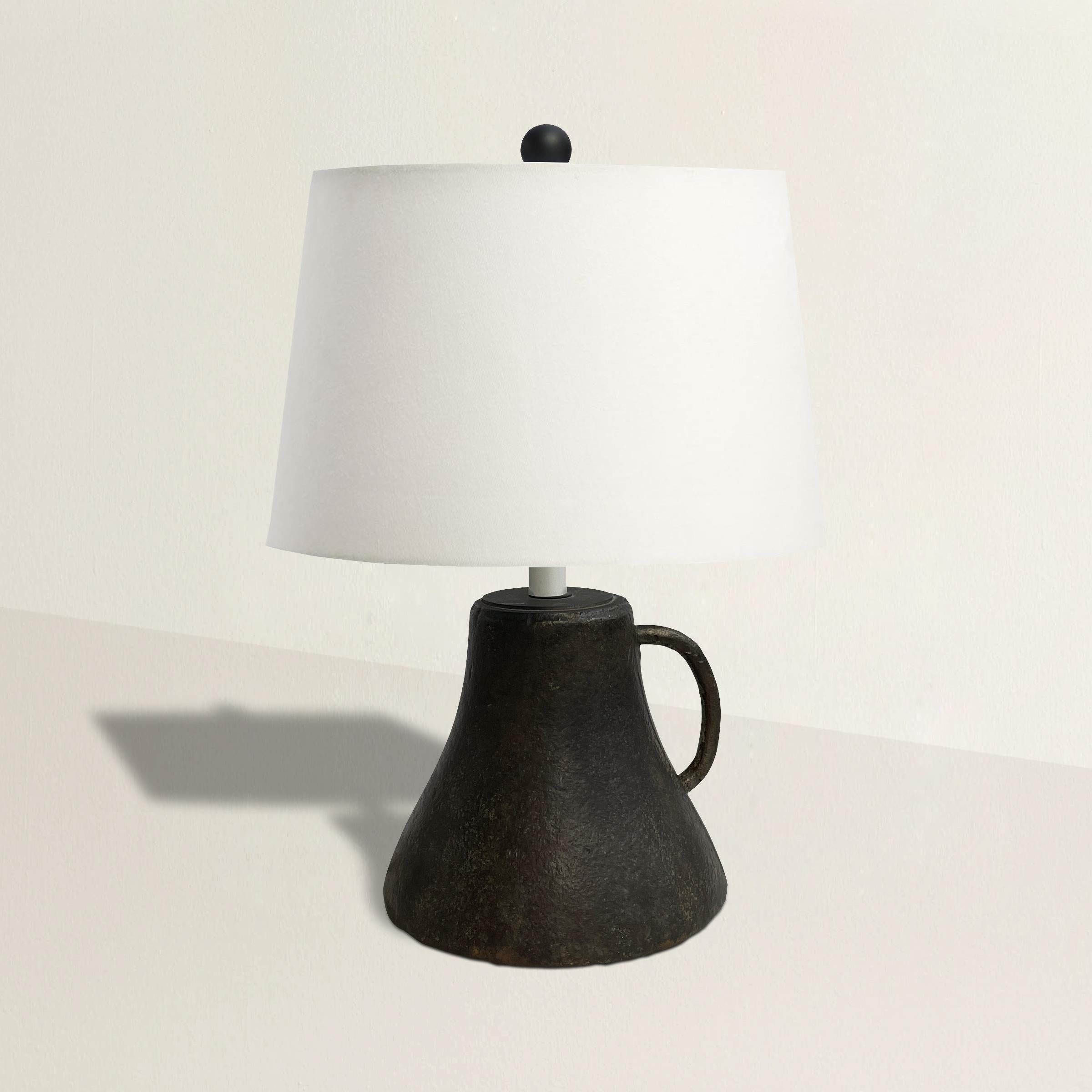 A bold and chic 18th century French iron mortar turned into a table lamp, with a new linen shade. Wired for US.