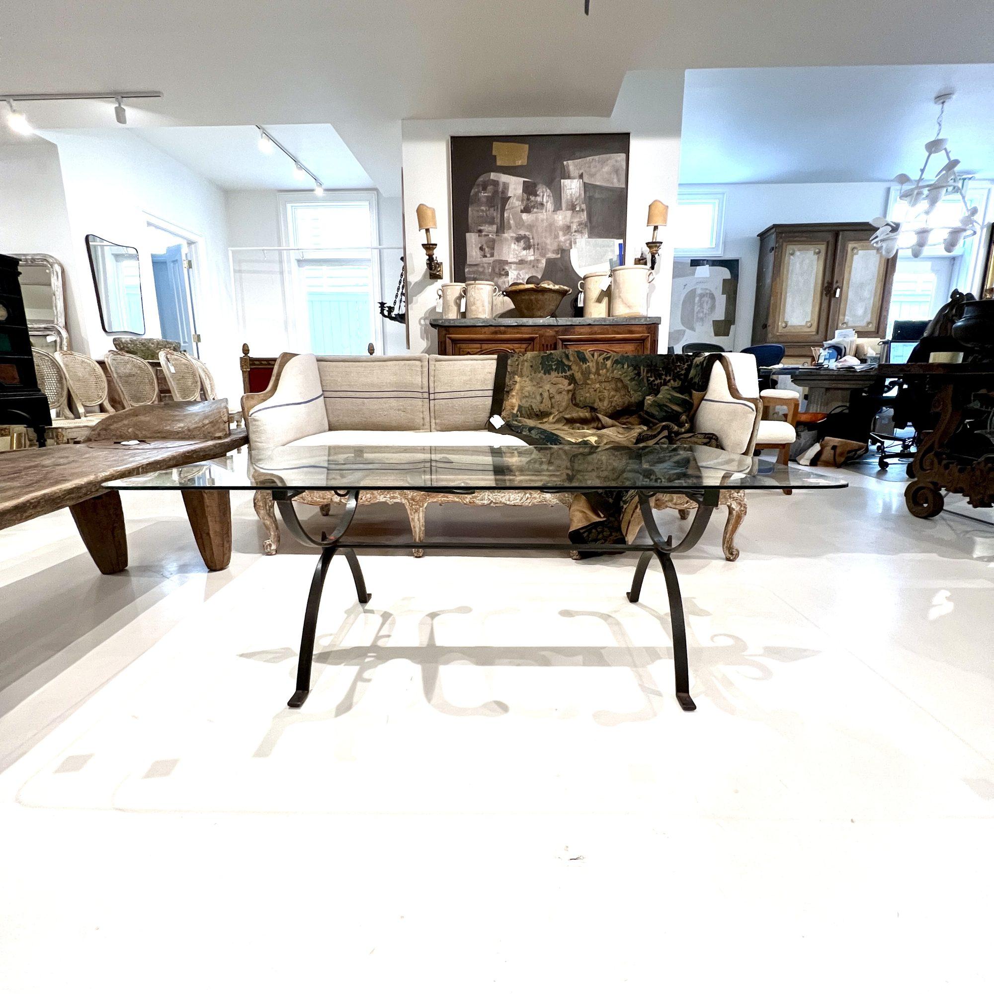 Table en fer du XVIIIe siècle avec plateau en verre - Combinaison frappante de design industriel et classique, cette table présente une base robuste en fer forgé à la main avec des détails complexes et un plateau en verre transparent. Le contraste