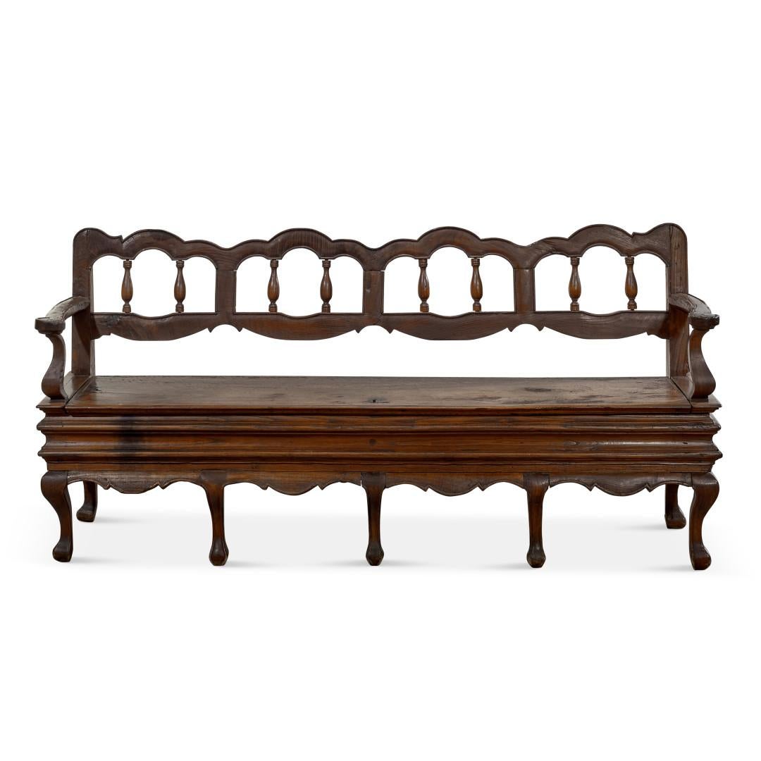This exquisite 18th-century Italian antique bench captures the essence of the Louis XV period, showcasing the craftsmanship of Venetian cabinetmakers. Crafted from solid walnut, the bench features elegant, undulating lines that embody the aesthetic