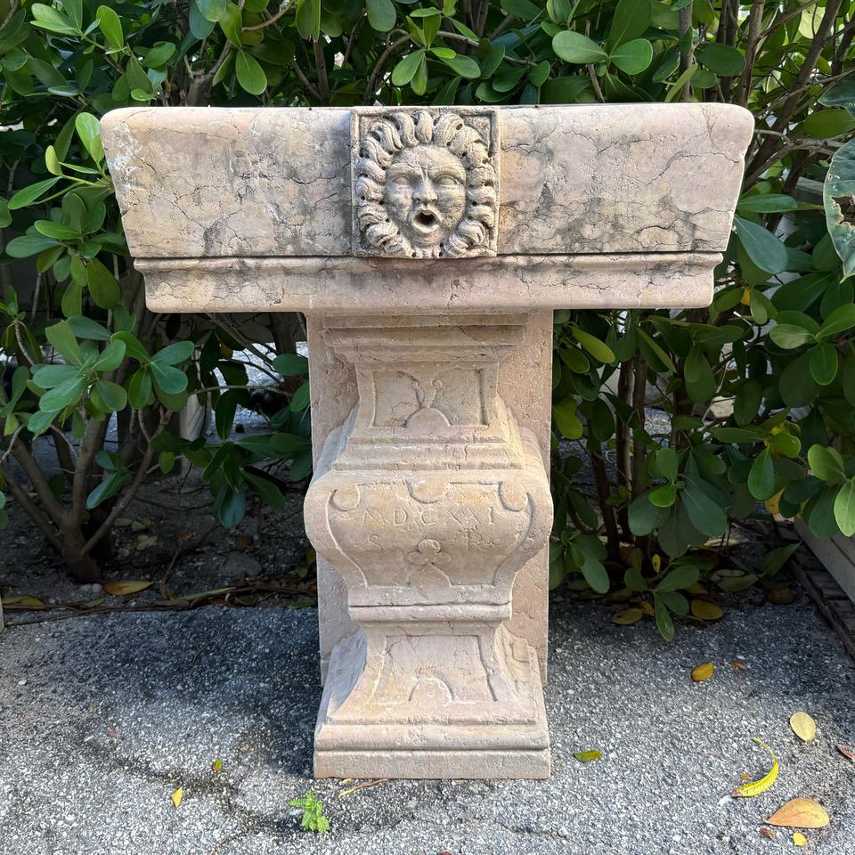 An antique Italian wall mounted fountain basin in a late Gothic style with central sun in low relief or 
