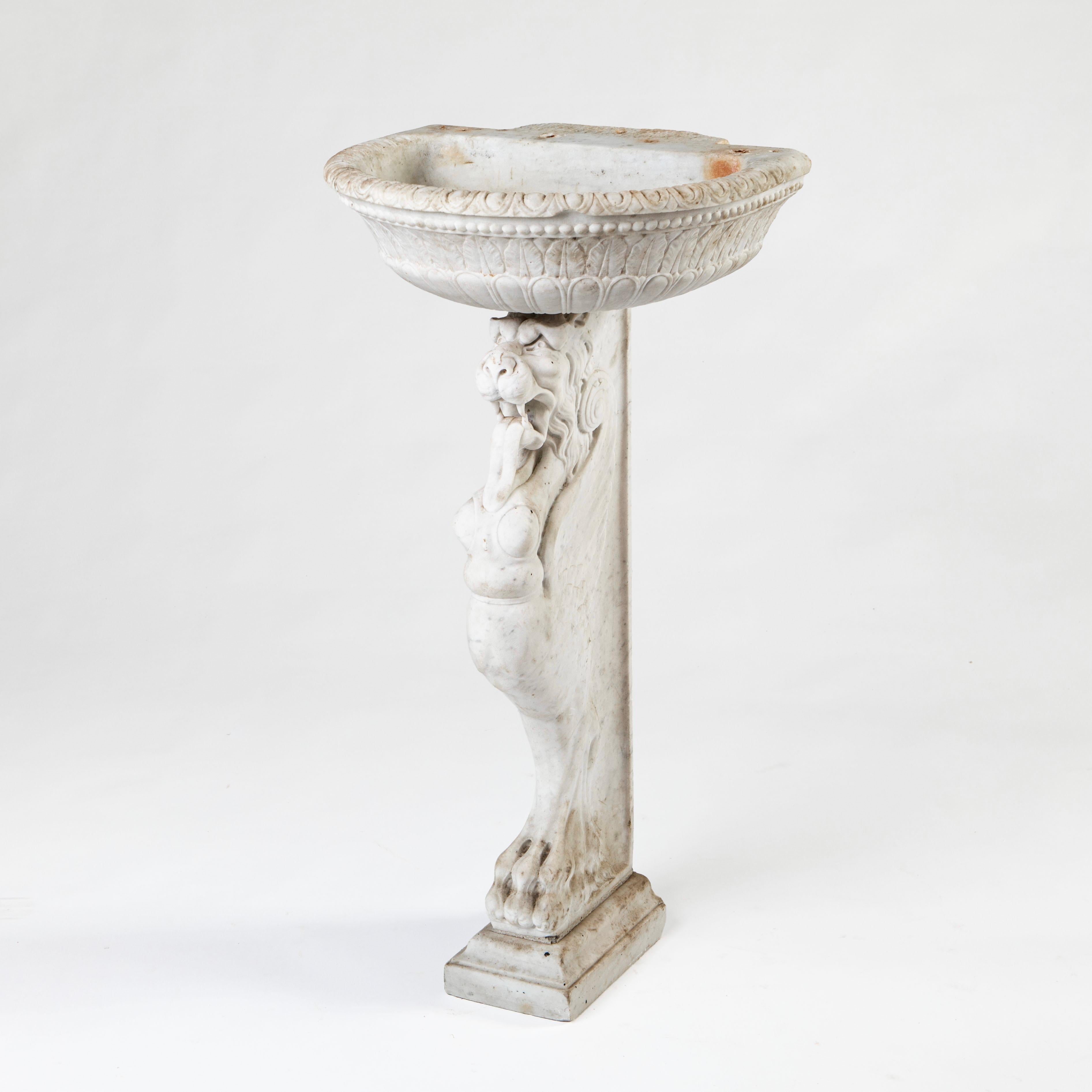 A decorative and charming Italian Baroque basin, crafted in fine white Carrara marble with fine hand-carved detailing throughout both the basin and pedestal.

The basin is adorned with carved acanthus leaf motifs in true Baroque style.  The bust is