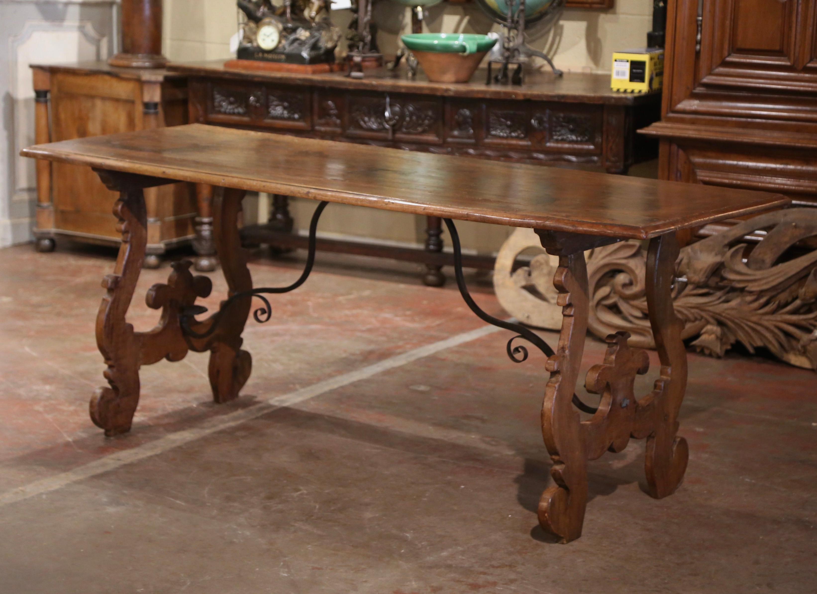 Add an elegant focal point to your hallway or den with this antique carved console table. Crafted in southwest Italy, circa 1760, and built in walnut, the large trestle table stands on hand carved scrolled ox yoke supports, and joined at the legs