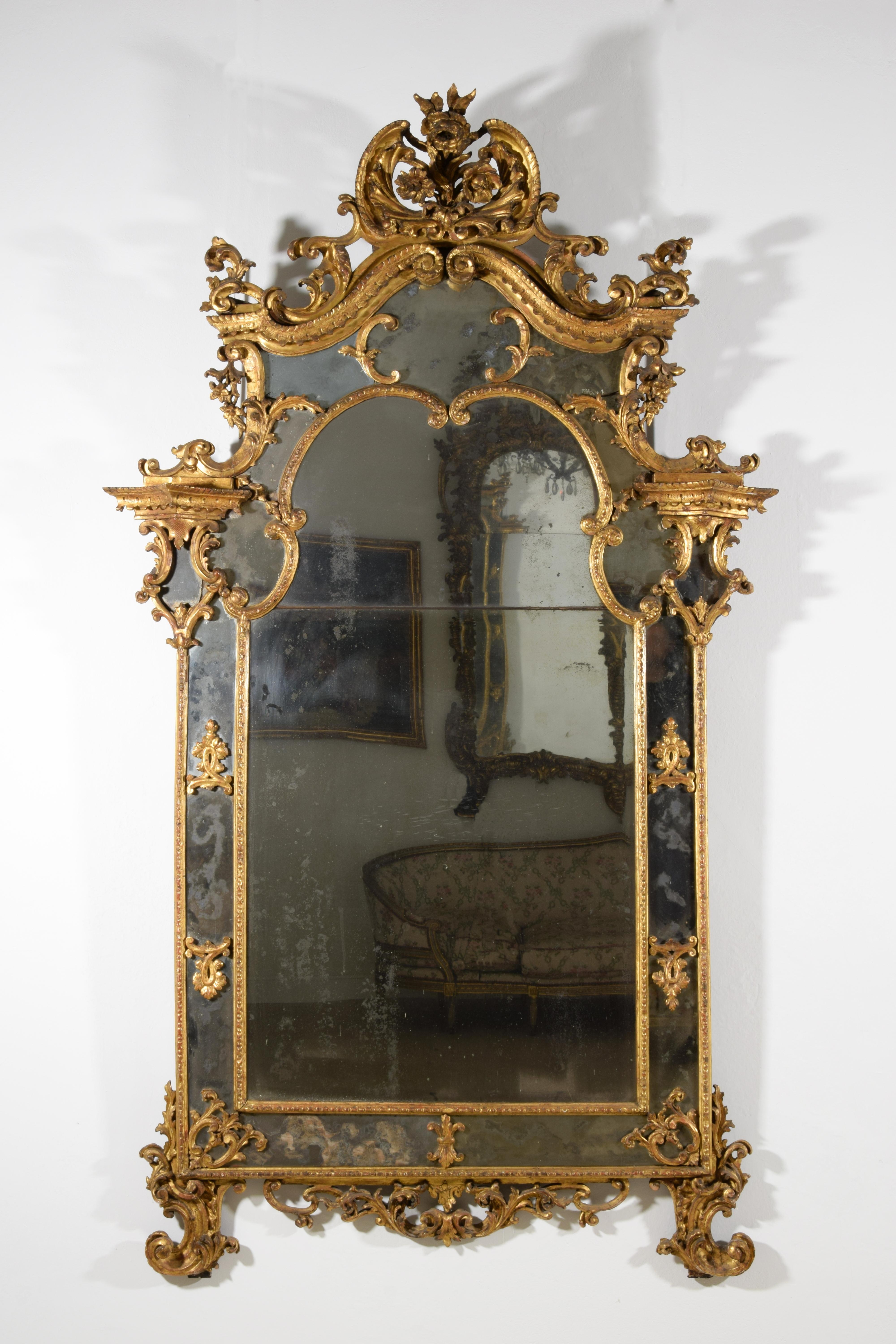 18th century, Italian Baroque Gitlwood Mirror 
This important mirror was made in Piedmont in the first half of the eighteenth century in the Baroque era. The structure in finely carved and gilded wood offers a refined and elegant decor inspired by