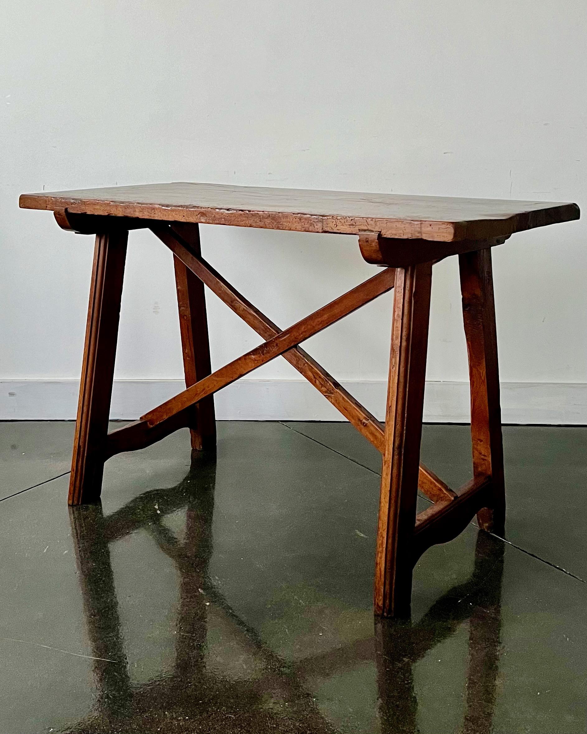 18th century Italian Baroque-style walnut side table .
Rectangle face with molded edge and raised on trestles and joined by strechere.