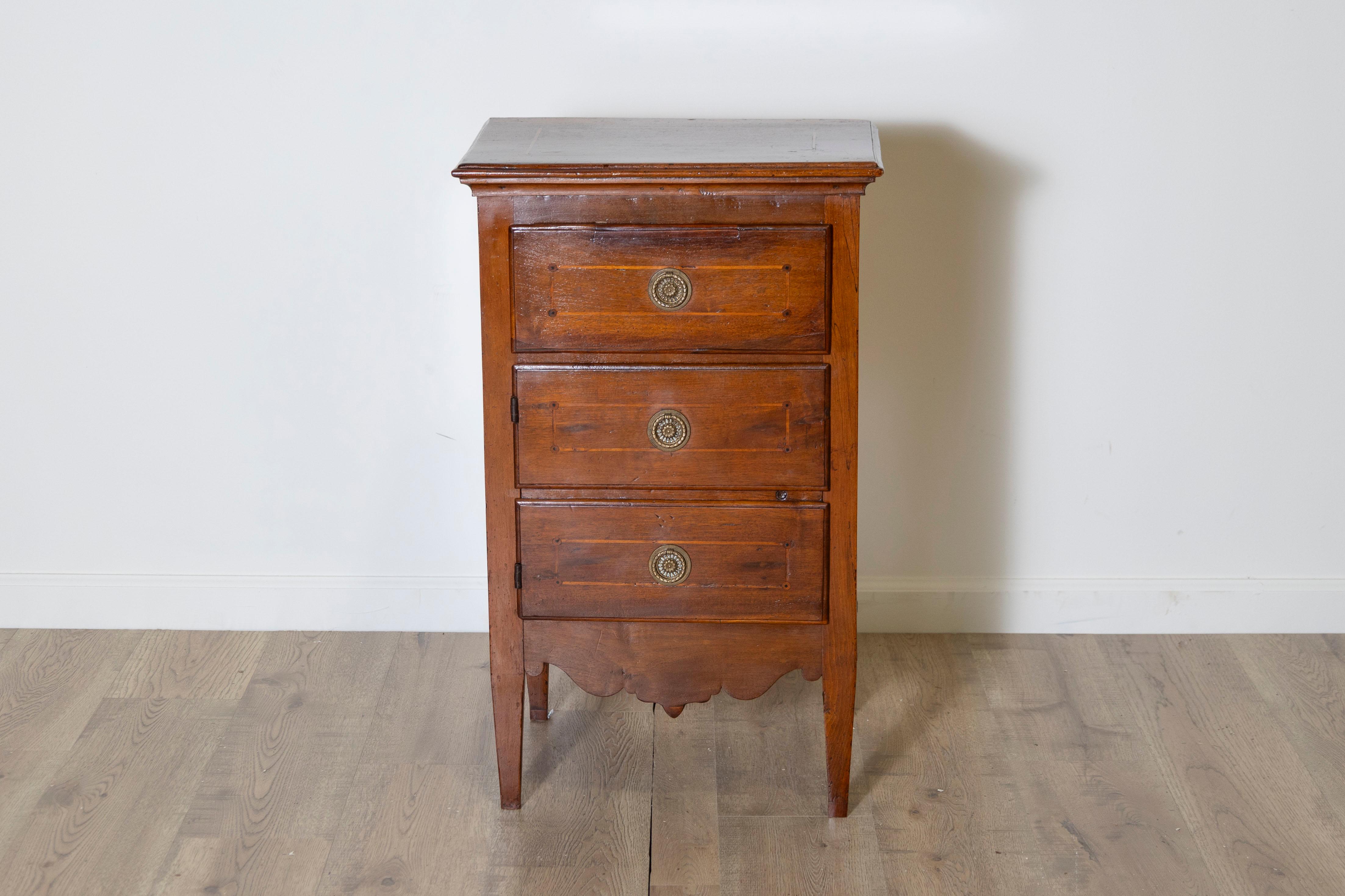This elegant 18th-century Louis XVI bedside table from Italy’s Veneto region beautifully embodies the refined craftsmanship of the period. Constructed from solid walnut and adorned with delicate marquetry inlays, the table features fine threading