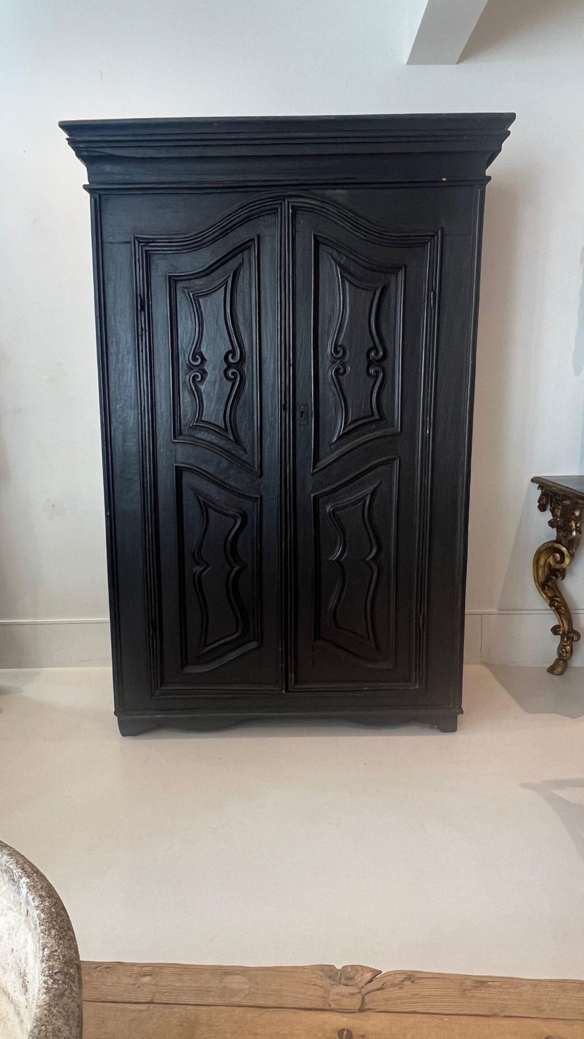 Cette armoire noire étonnante offre de nombreux rangements et constitue une pièce à part entière dans tout décor.