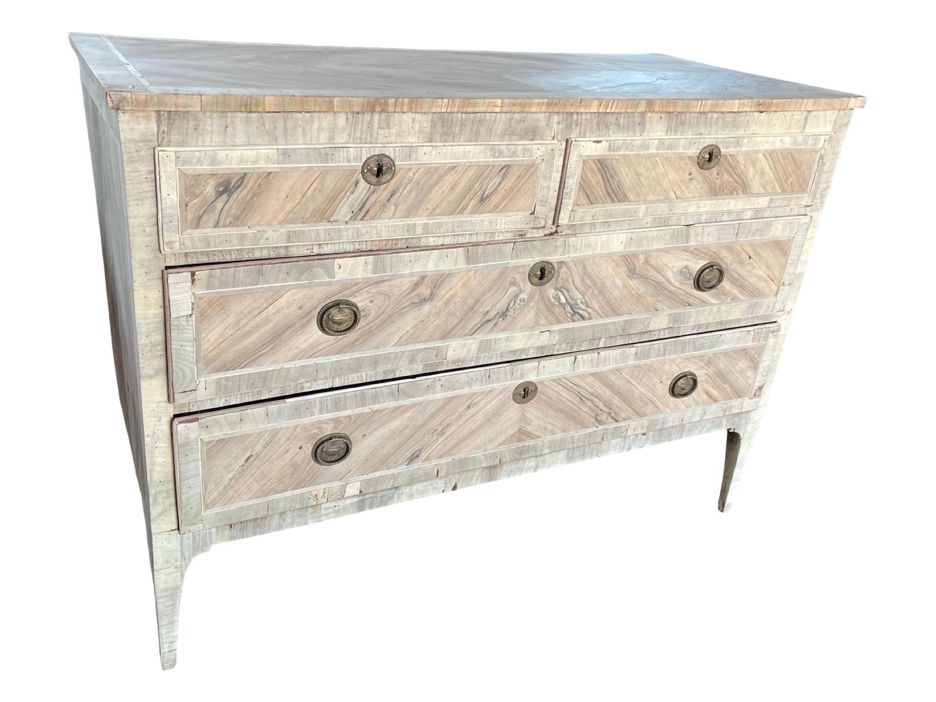 Commode neoclassica realizzata a mano in Italia alla fine del 1700 con legno di quercia e decorata con impiallacciatura di noce. La cassettiera presenta le tipiche linee rette dello stile neoclassico, con gambe affusolate e angoli dritti. La commode