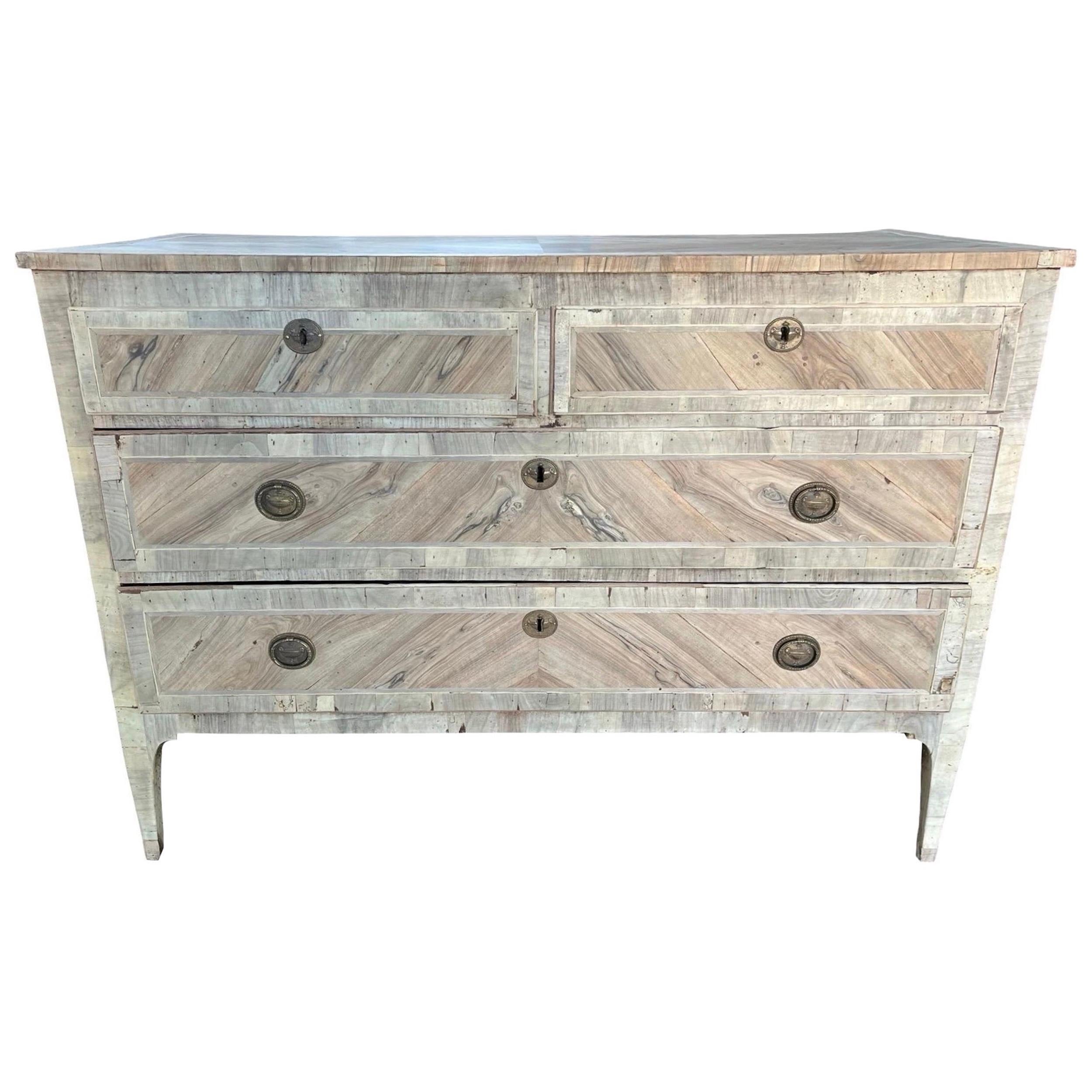 Commode neoclassica realizzata a mano in Italia alla fine del 1700 con legno di quercia e decorata con impiallacciatura di noce. La cassettiera presenta le tipiche linee rette dello stile neoclassico, con gambe affusolate e angoli dritti. La commode