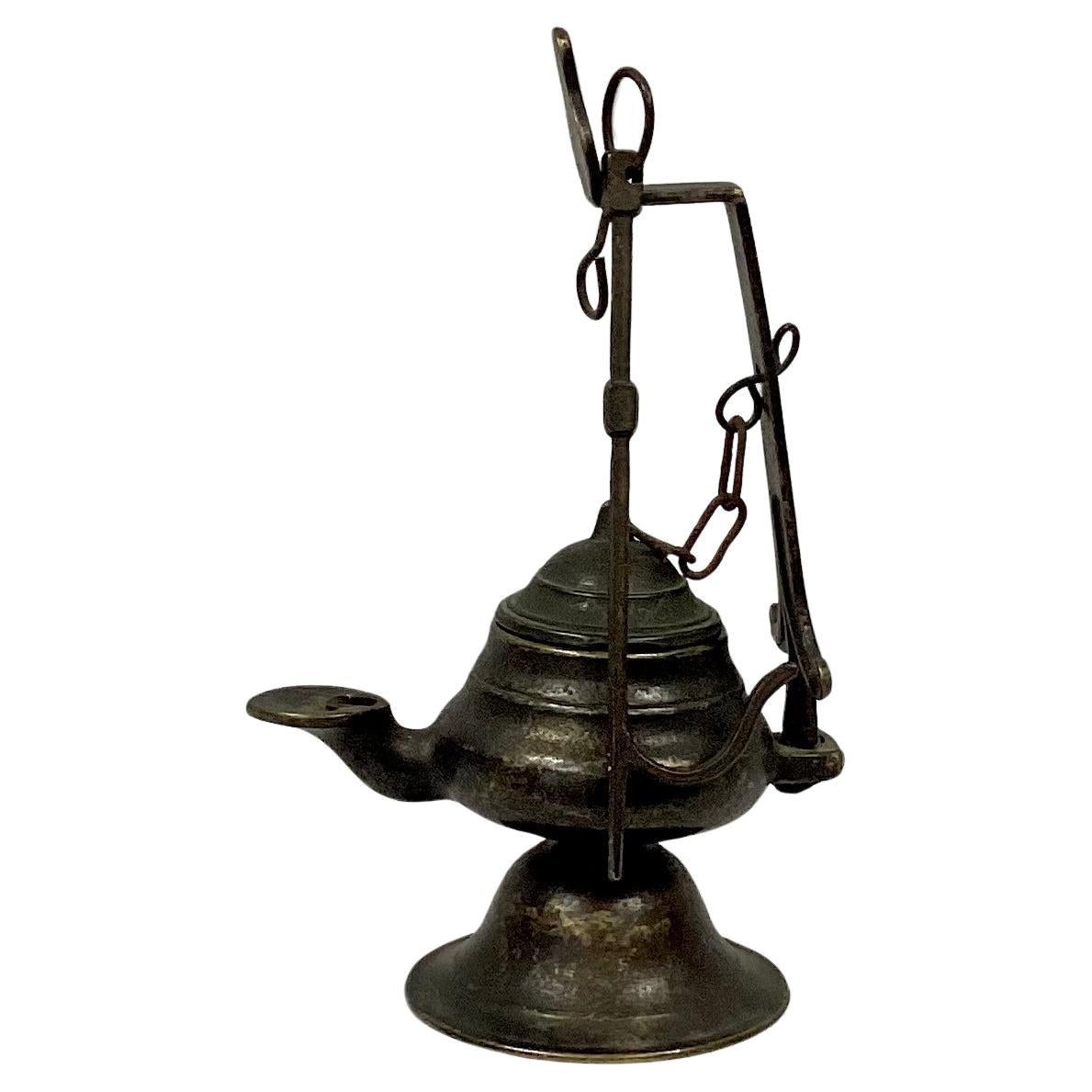 18th Century Italian hanging bronze oil lamp with removable lid. Solid bronze. Can be hung or used as a stand-alone decorating piece. Great piece to use with any decor.  Dimensions listed are including hanging bar. Oil lamp by itself is is 3.5