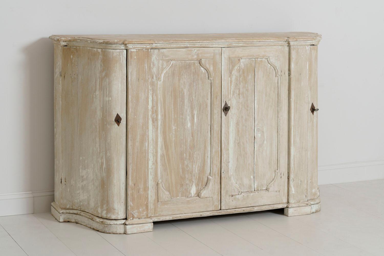 A beautifully refined Italian buffet in original paint with breakfront and serpentine shaped sides from the 18th century. The interior features two shelves in the centre and two shaped shelves on the sides. This is a fabulous transitional piece
