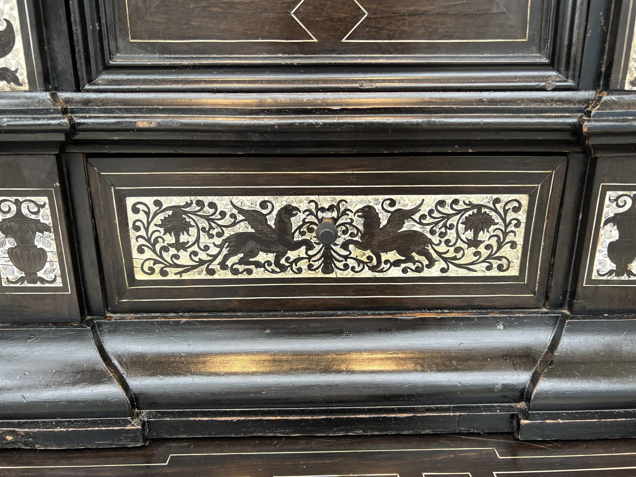 Behold this extraordinary cabinet by Fernando Pogliani from Milan that is a layered fantasia of ebony and bone. The front is intricately worked inlay depicting everything from angels and horses to peacocks and griffons. This is truly a wholly unique