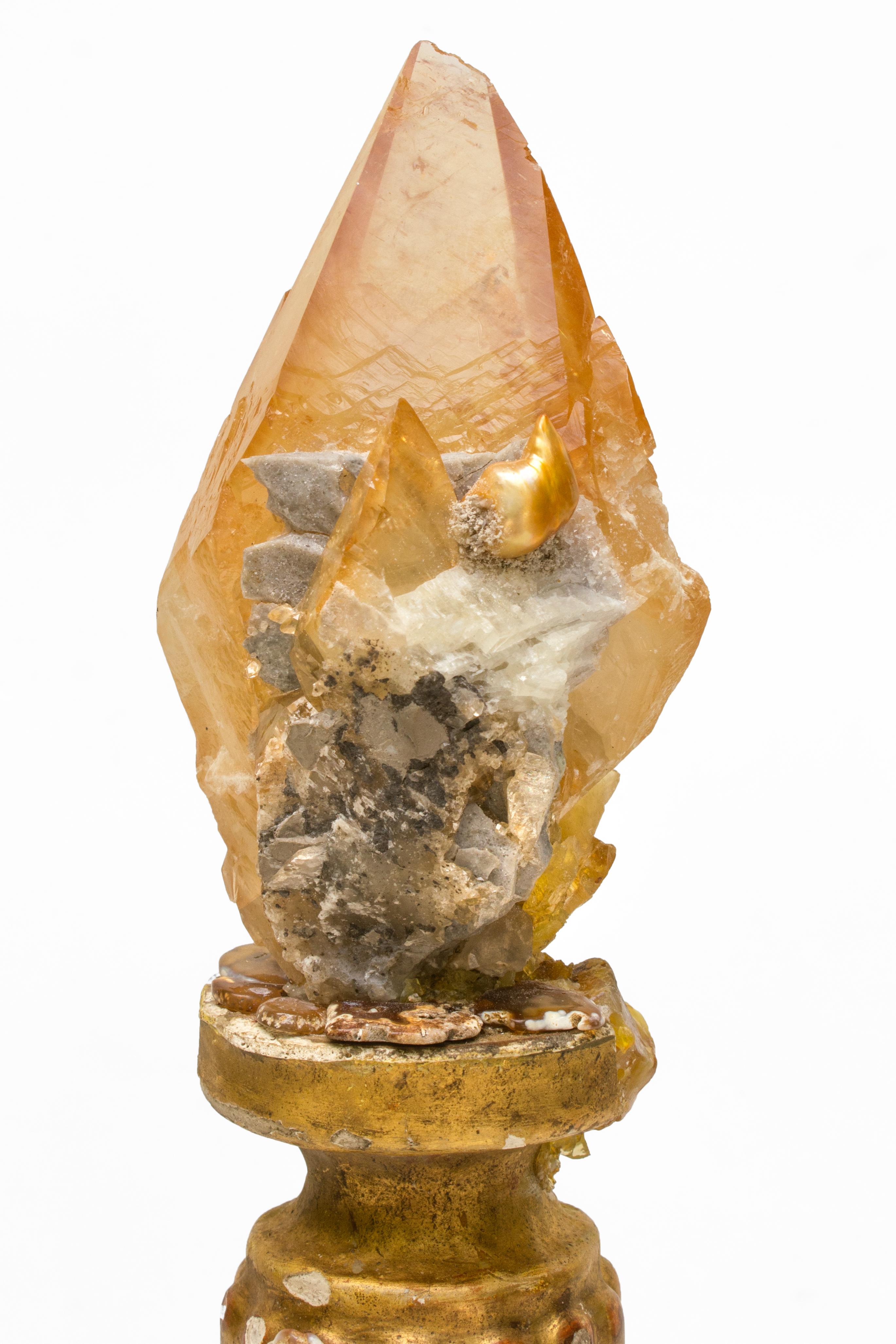 18th century Italian candlestick with a calcite crystal and a natural forming baroque pearl. The candlestick is decorated with polished agatized coral pieces and sits on a coordinating agate base.

These calcite crystals are from Elmwood Mine,