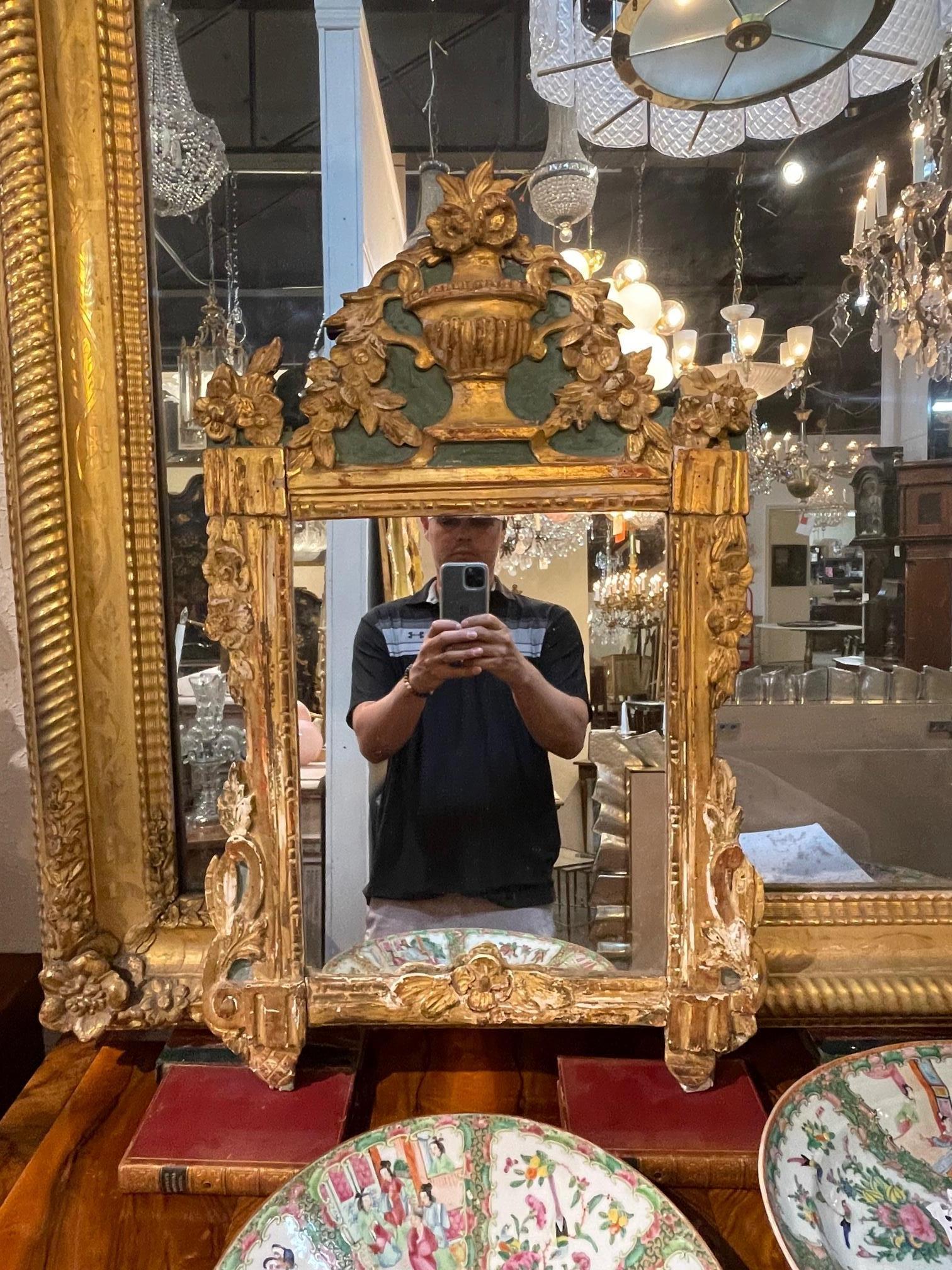 Very fine 18th century Italian carved giltwood mirror. Exceptional carvings including an urn with over flowing flowers. A fabulous focal point for a beautiful room! Lovely patina as well!.