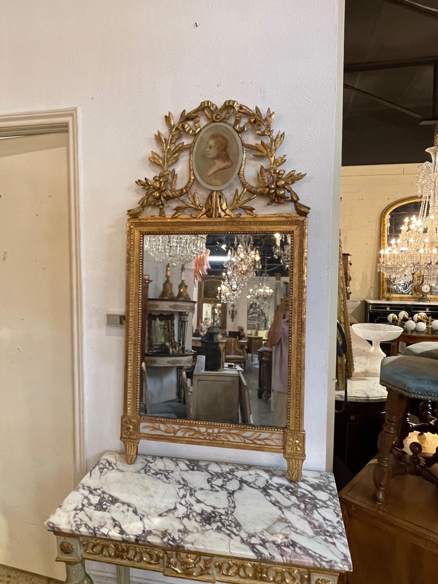 Gorgeous 18th century Italian carved and parcel gilt neoclassical mirror. Exceptional carvings and a lovely painted image of a woman at the top. A very fine piece!!