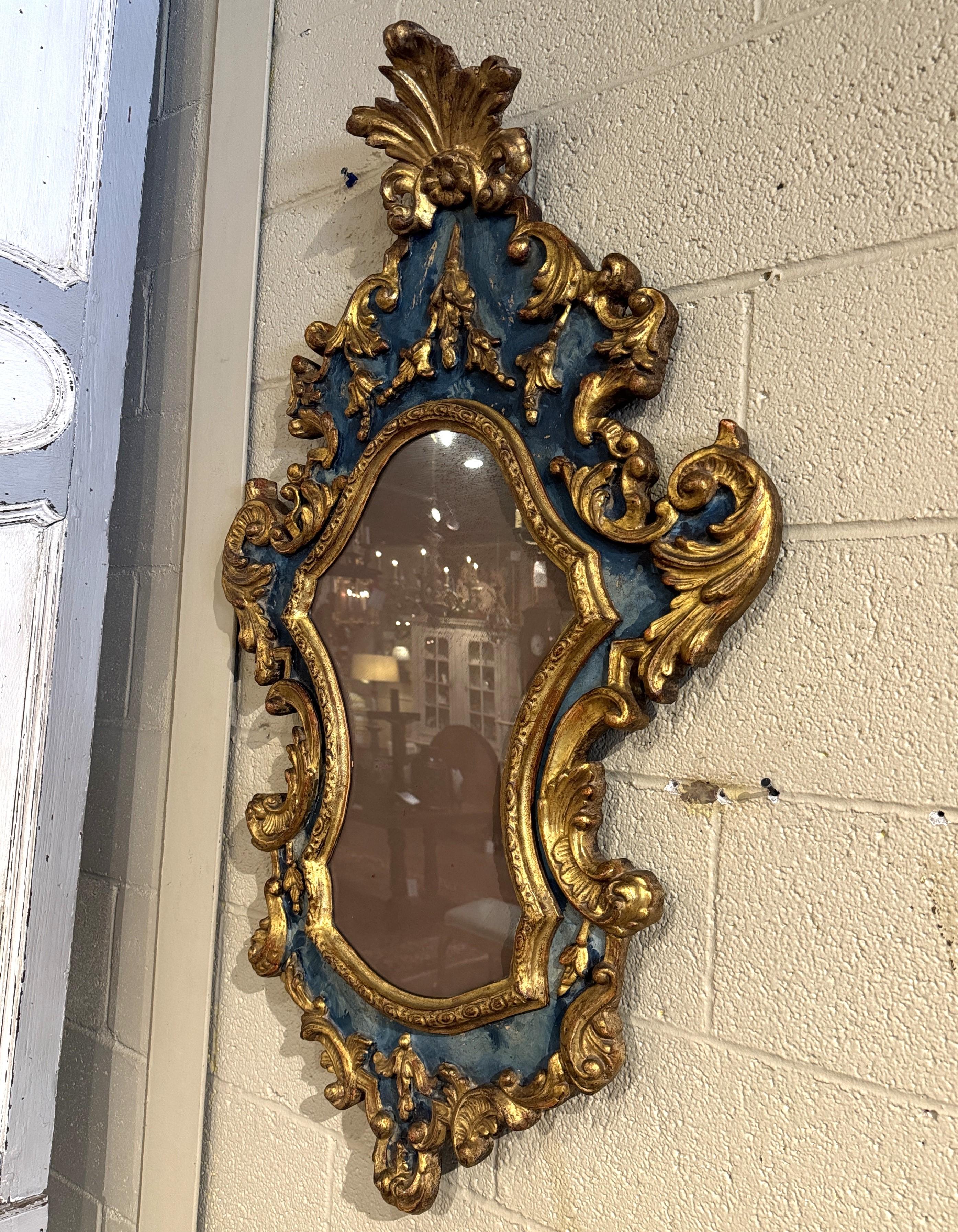 Decorate an entry or hallway with this antique wall decor. Crafted in Italy, circa 1760, this ornate frame features an elaborate baroque-style frame with gilded scroll work associated with a teal-blue background. The frame is intricately carved,