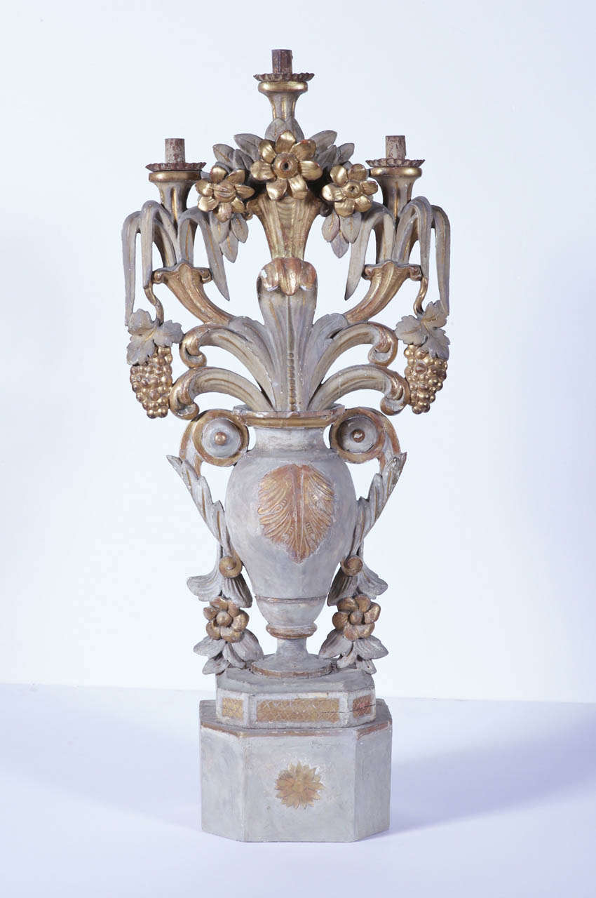 Make an elegant statement in your home with this tall, ornate antique candelabra. Crafted in Italy, circa 1780, the candle holder stands on a square base; it features three arms and metal bobeches over a central shaped vase embellished with hand