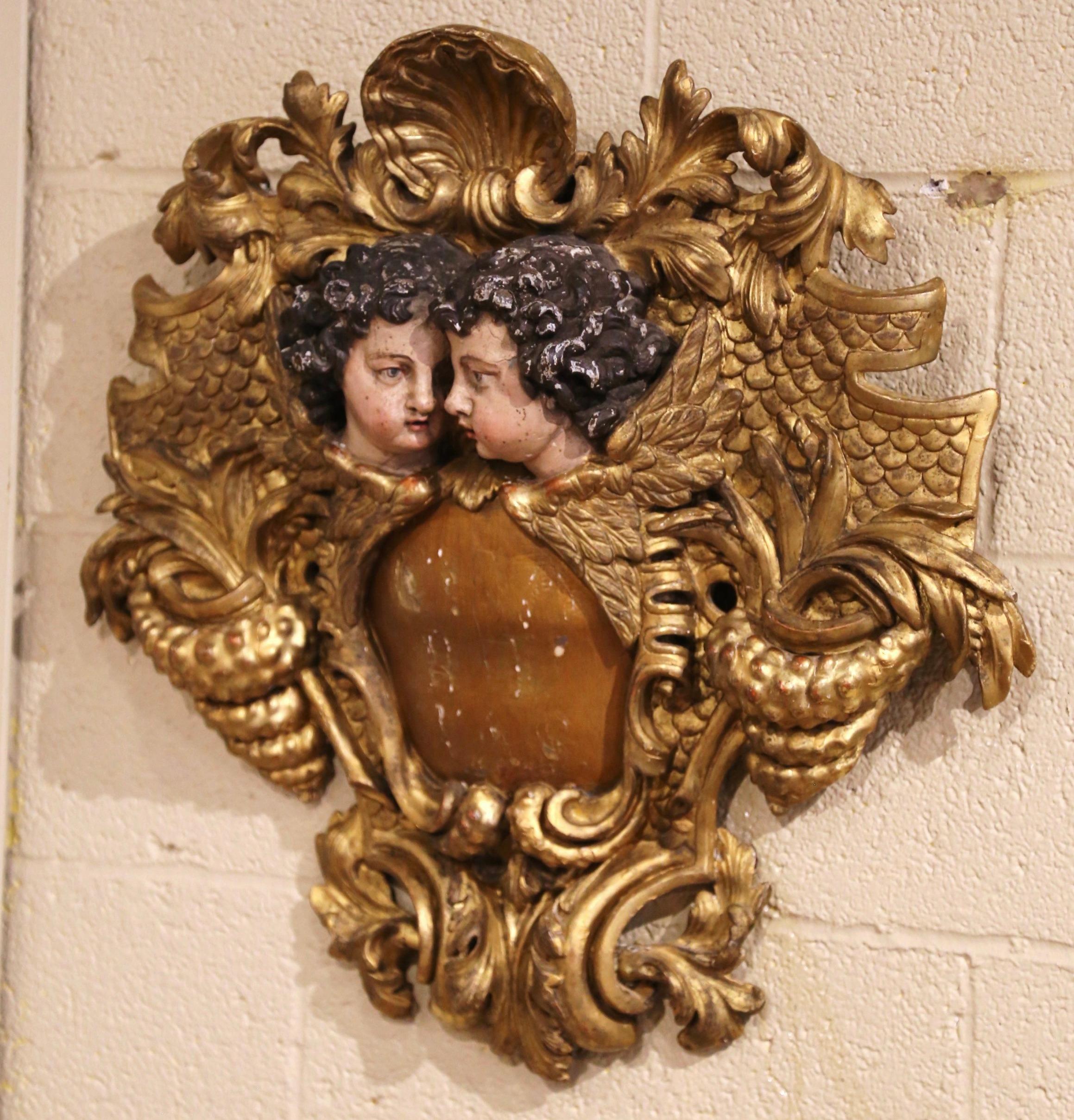 Embellish a mantel or study with this important antique wood carving crest. Crafted in Italy, circa 1760, the elegant wall-mounted plaque features carved scrolls throughout including in the center two polychromed cherubs with wings looking at each