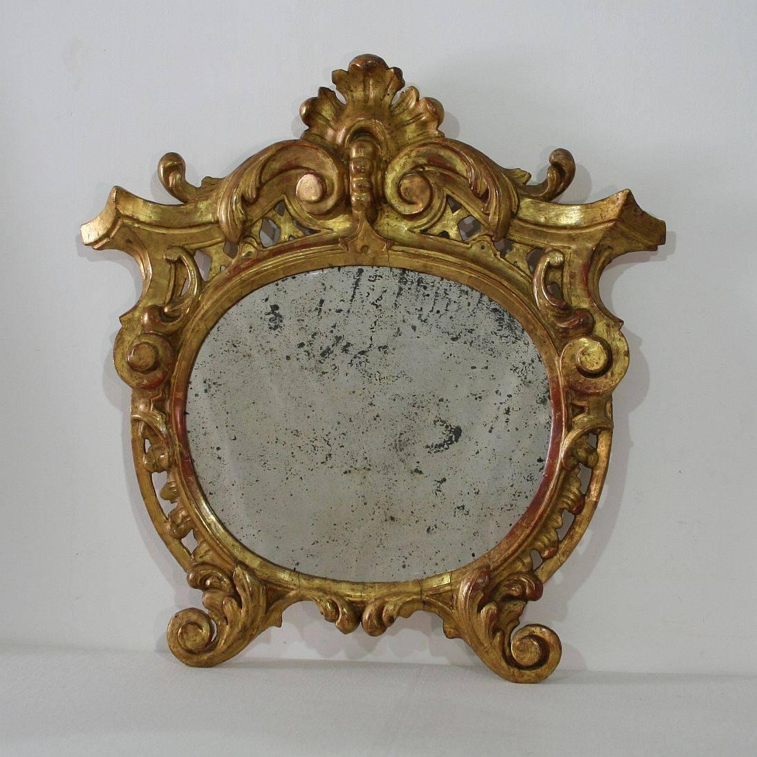 Beautiful carved giltwood Baroque mirror, with original mirror glass, Italy, circa 1750. Weathered.