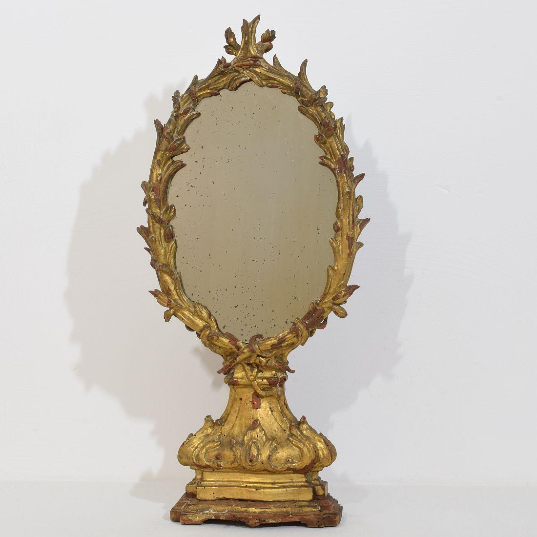 Wonderful and unique carved gilt wood baroque standing mirror with a beautiful crumbly patina, Italy, circa 1750. Beautiful weathered, small losses and old repairs. Despite of its high age in a relative good condition. Treated against woodworm.