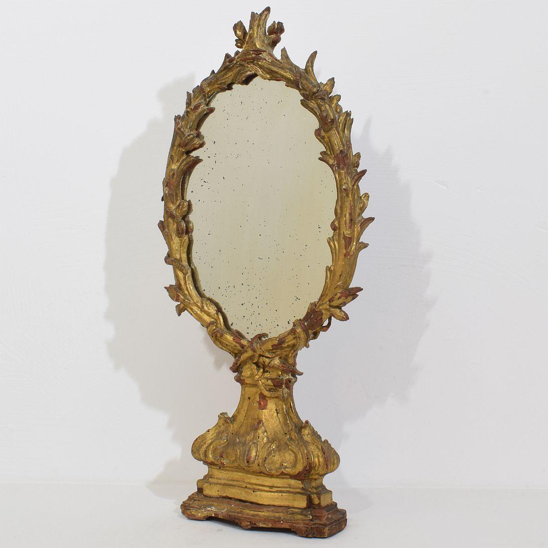 Merveilleux et unique miroir baroque en bois sculpté et doré, avec une belle patine friable, Italie, vers 1750. Belle usure du temps, petites pertes et réparations anciennes. Malgré son âge élevé, elle est en relativement bon état. Traitée contre