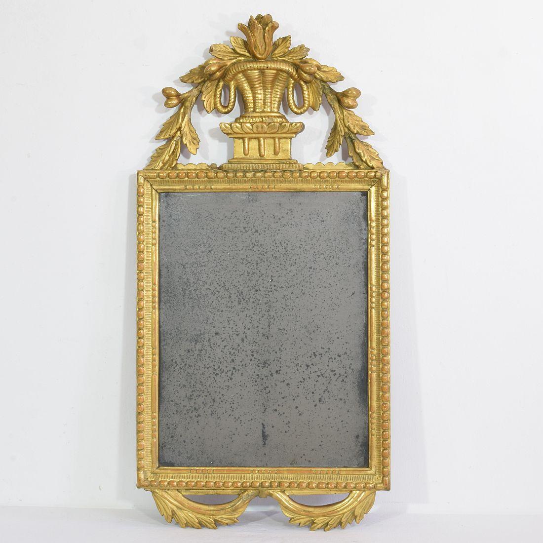 Wonderful Italian carved giltwood Louis XVI mirror, with its beautiful foxed old mercury mirror glass,
Italy, circa 1770-1790. Weathered, small losses and old repairs.