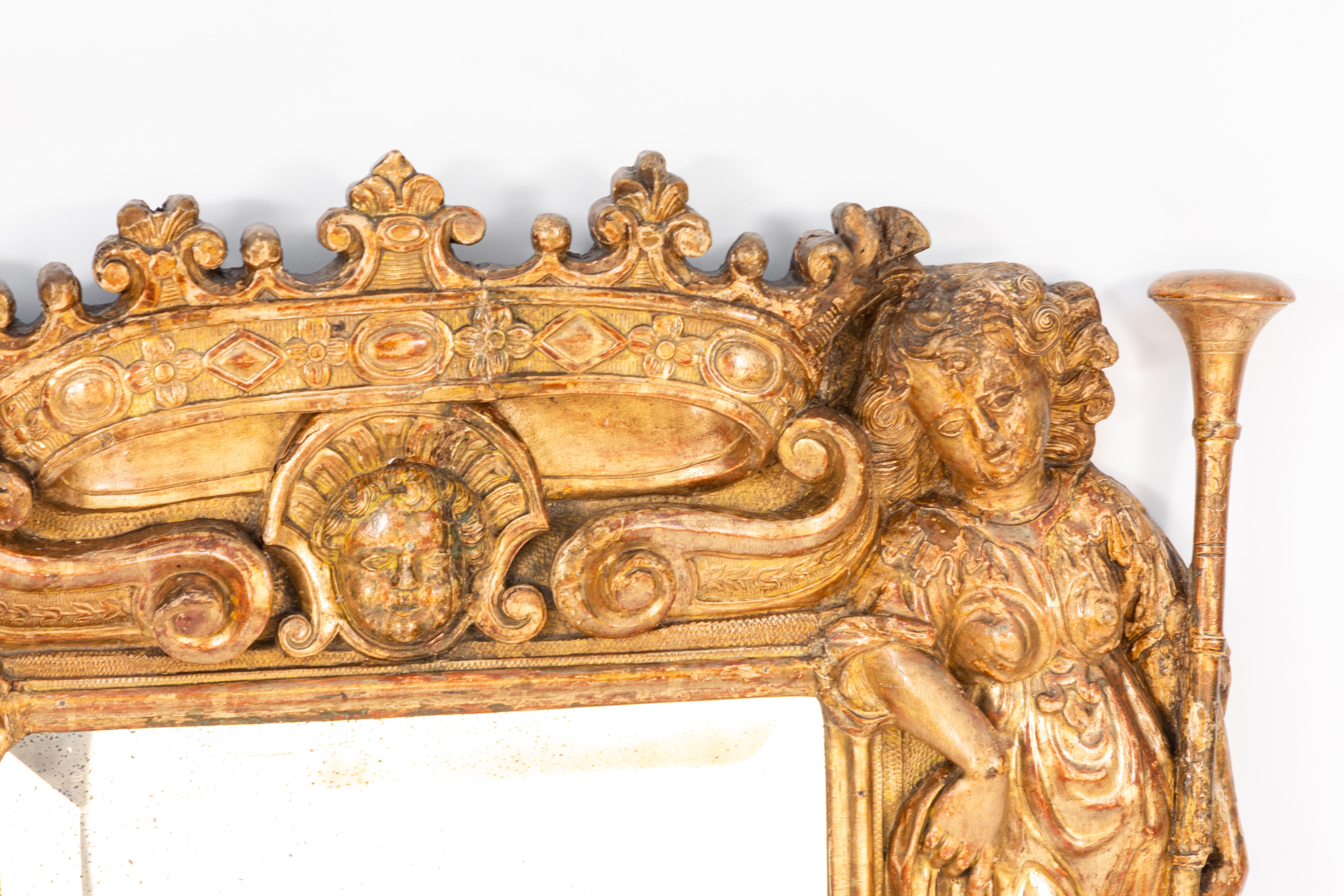 Early 18th century Italian giltwood mirror with finely carved details throughout. Cherub and crown motif. Original gilt finish. Beautiful patina.