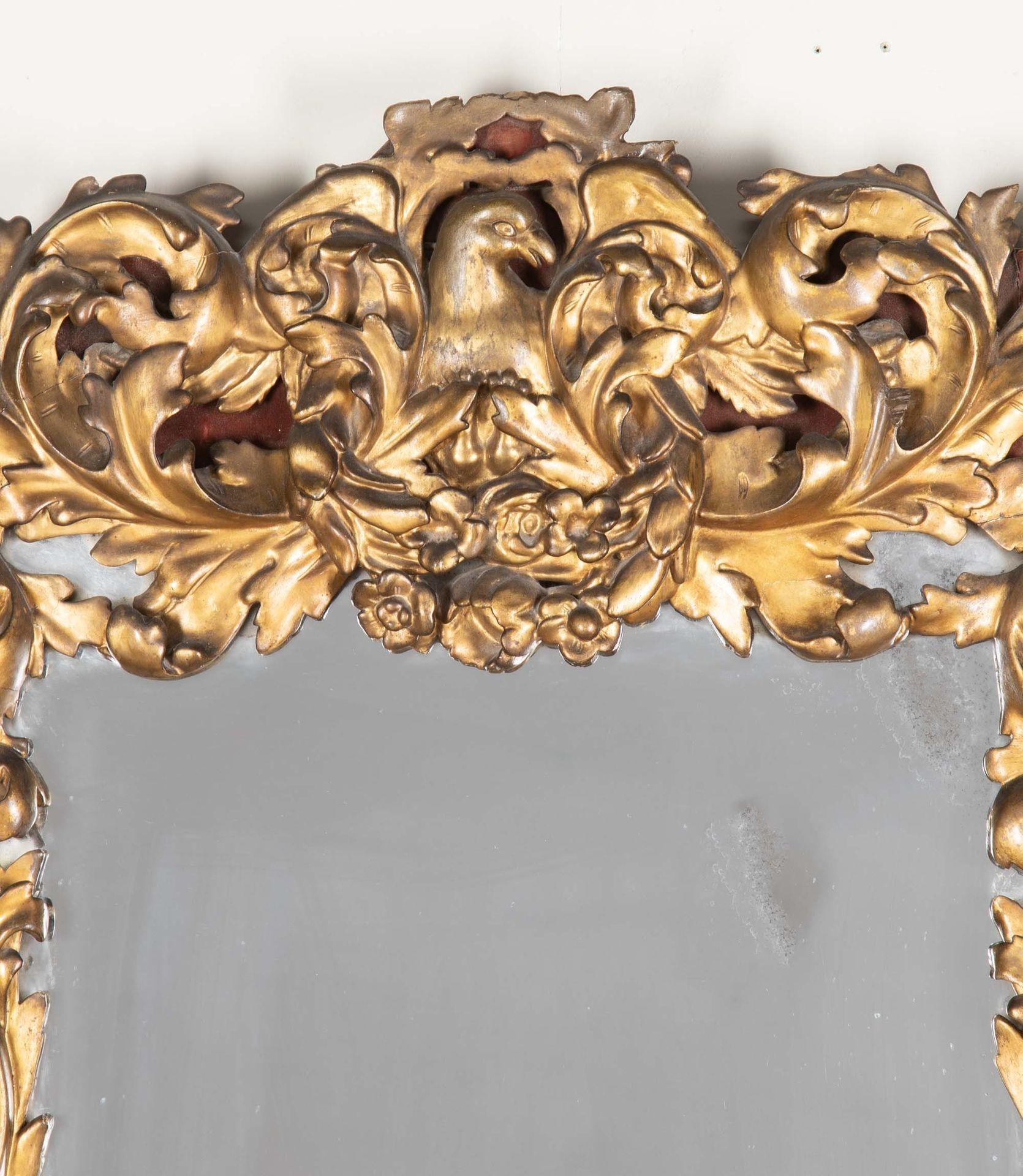 Espejo italiano de madera dorada del siglo XVIII.
Con volutas talladas encabezadas por un águila y rematadas por guirnaldas de flores talladas.