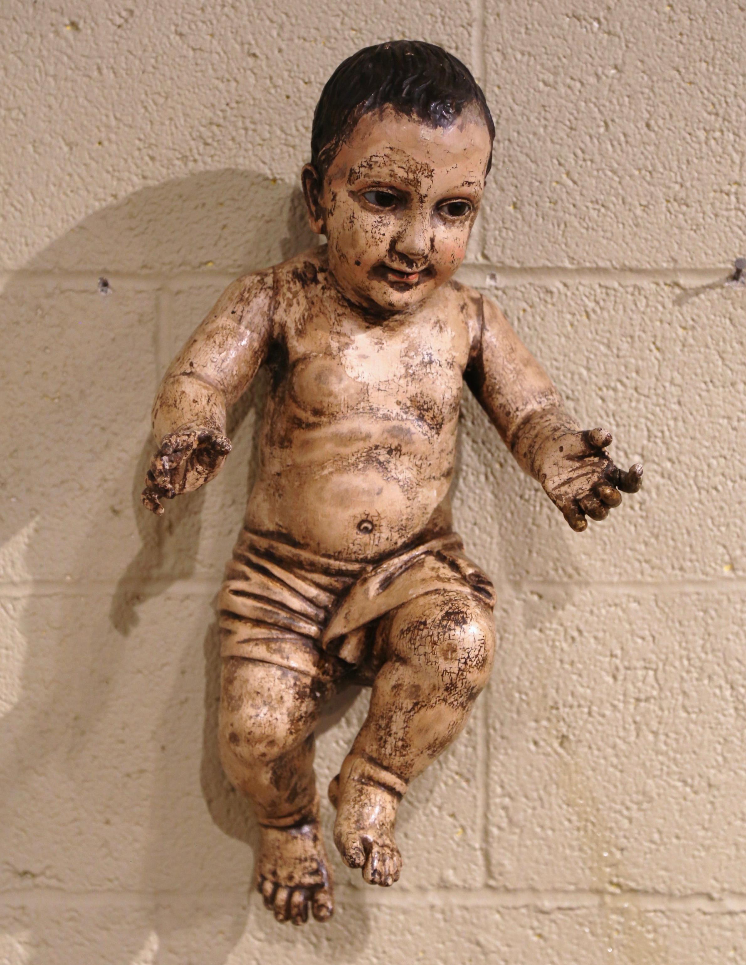 Diese antike Jesuskind-Figur wurde um 1780 in Italien hergestellt. Die handbemalte Puttenschnitzerei hat ihre originale mehrfarbige Oberfläche für ein luxuriöses Ergebnis. Der handgeschnitzte Cherub mit Glasaugen ist ausdrucksstark in seinen