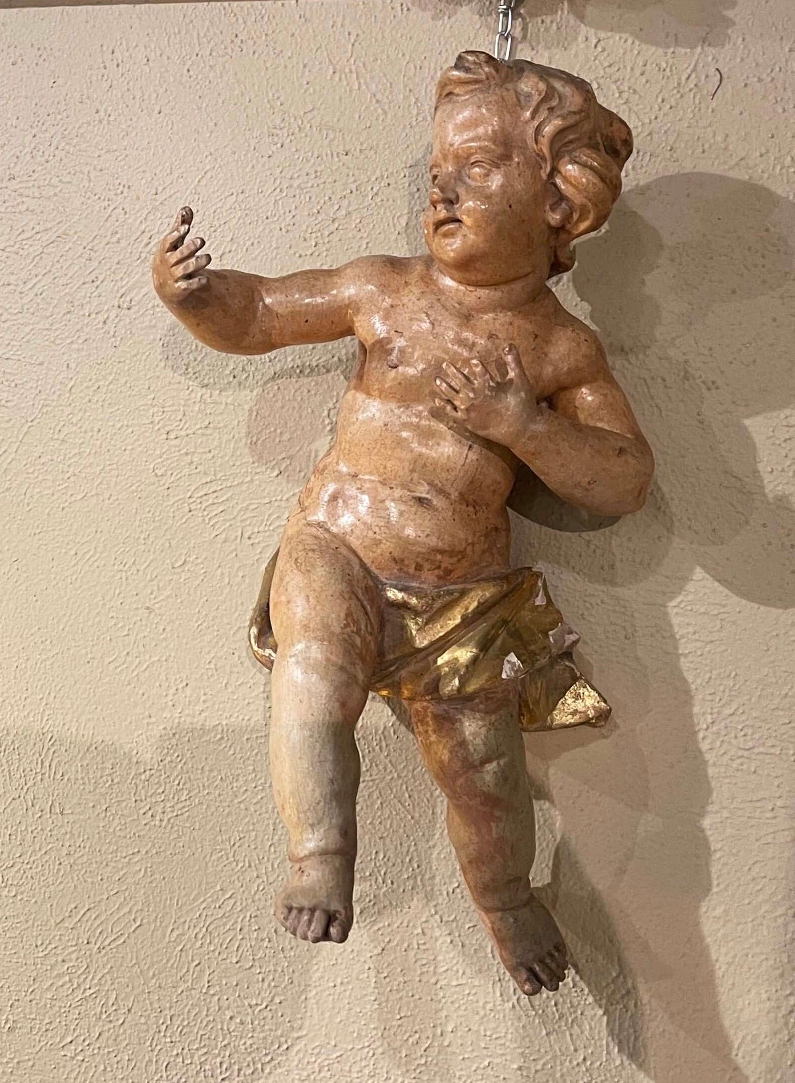 Diese antike Cherub-Figur wurde um 1780 in Italien hergestellt. Die handgemalte Puttenschnitzerei hat ihre ursprüngliche mehrfarbige und blattvergoldete Oberfläche für ein luxuriöses Ergebnis. Der handgeschnitzte Cherub ist ausdrucksstark in seinen