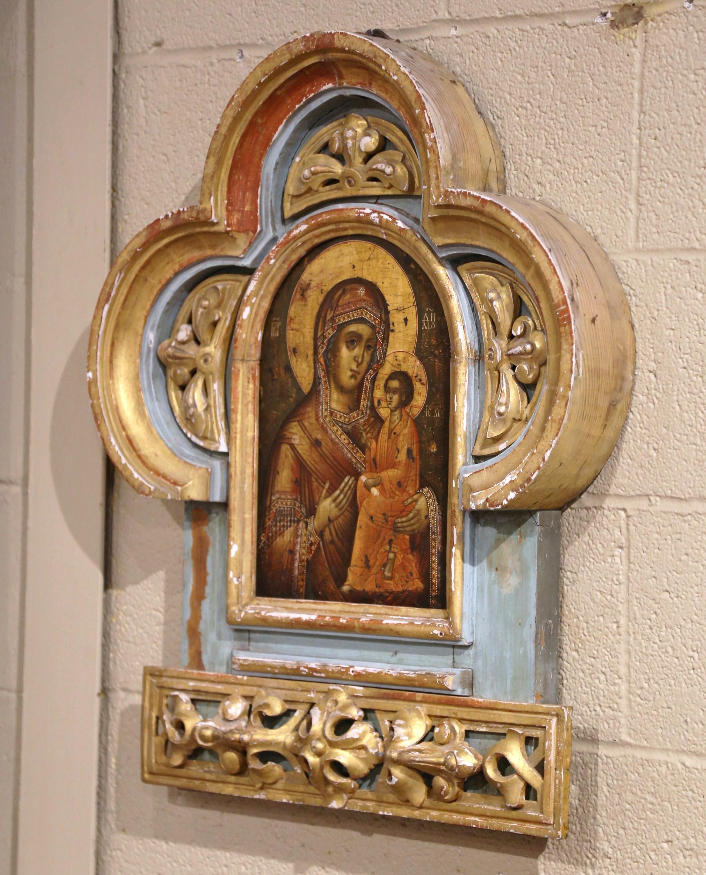 Decorate a library or study with this elegant and colorful antique wall sculpture. Crafted in Italy circa 1760, the religious gilt wood wall decor features a arched top and sides decorated with inset hand carved leaf motifs medallions. The center is