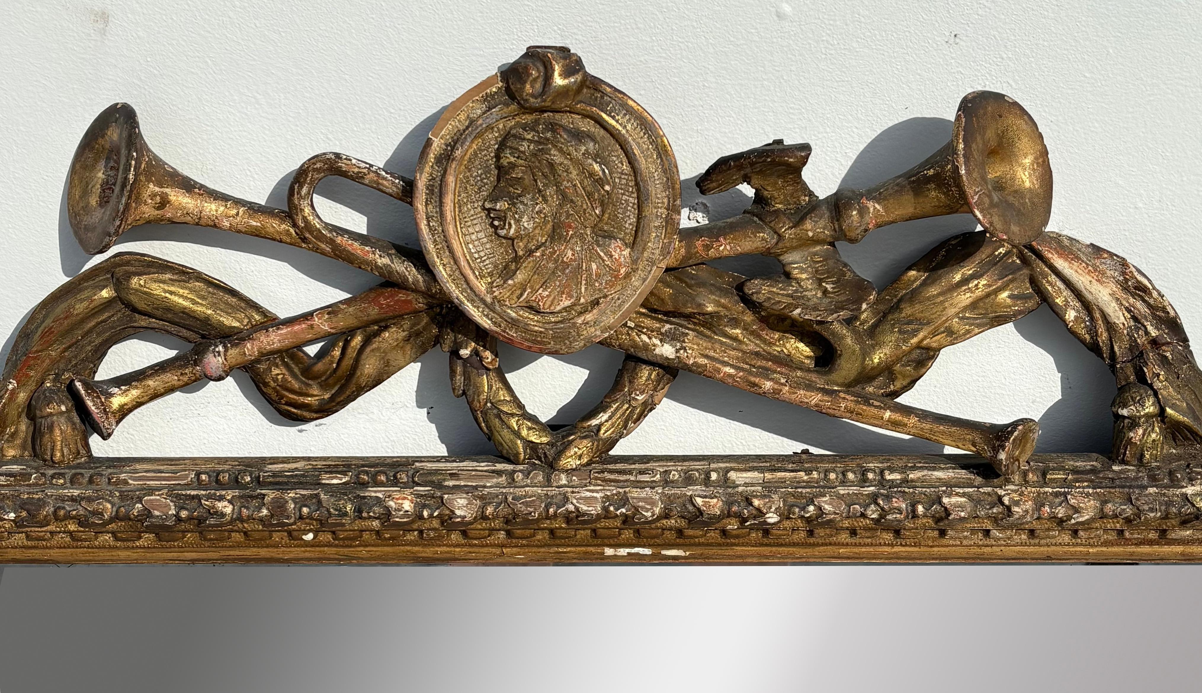 Espejo italiano tallado y dorado de mediados del siglo XVIII con un  cresta de asta coronada por una cartela oval que contiene el busto de un hombre con tocado medieval, probablemente Dante.  La superficie es original y se ve muy bien. El pasaje