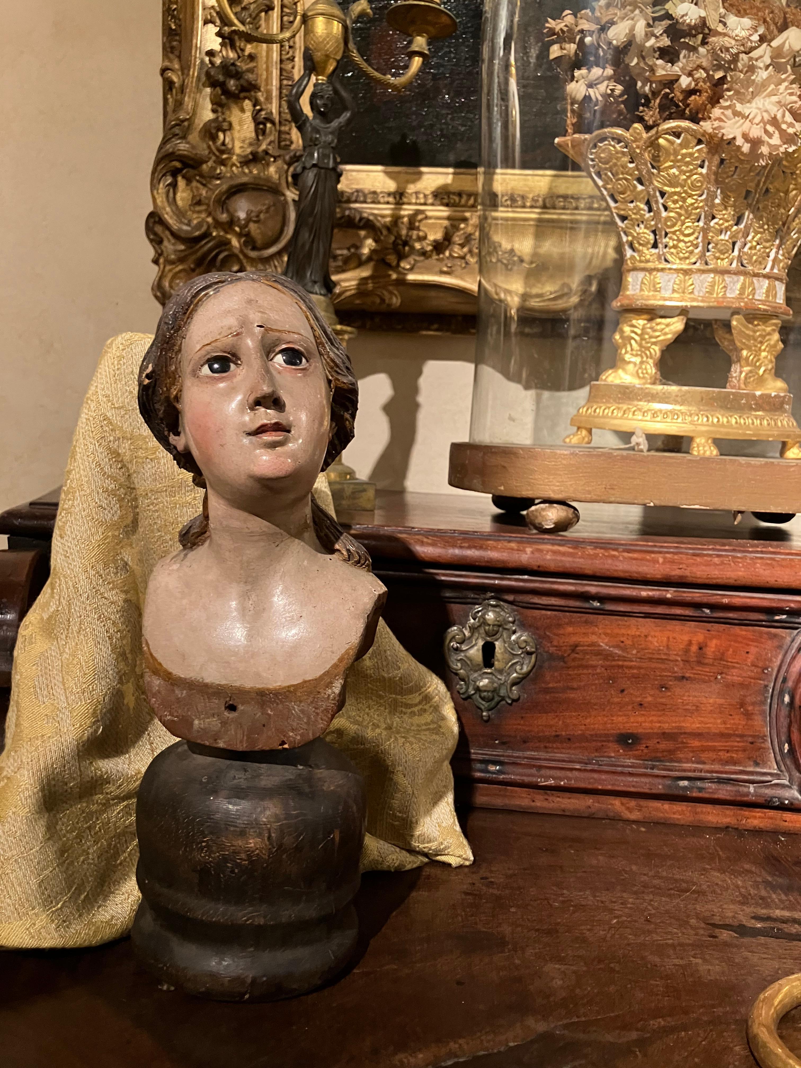 Este busto femenino italiano de madera, magistralmente tallado y lacado, ejemplifica la exquisita maestría del arte religioso del siglo XVIII. Elaborada con excepcional habilidad y precisión, esta cabeza femenina tallada y lacada policromada ofrece