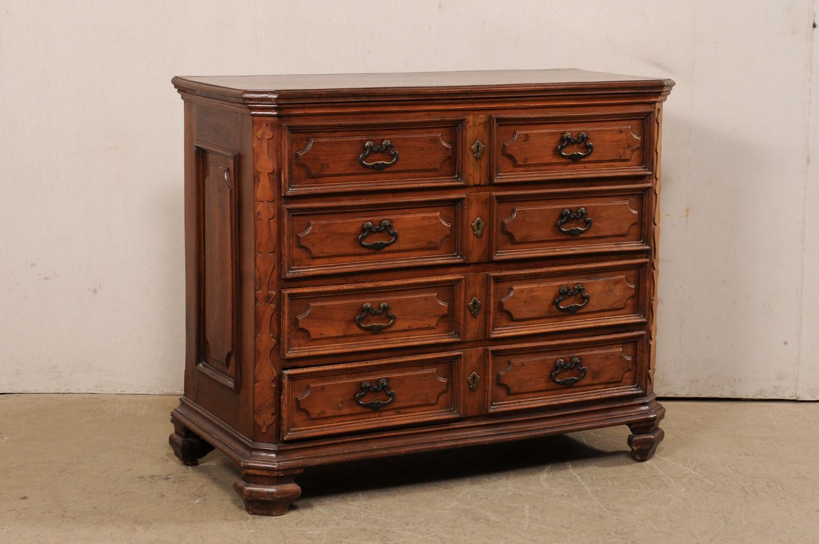 An Italian walnut chest of drawers from the 18th century. This antique cassettiera (chest of drawers) from Italy features a rectangular-shaped top with canted front corners, atop case which houses four graduated drawers, flanked within fluted and