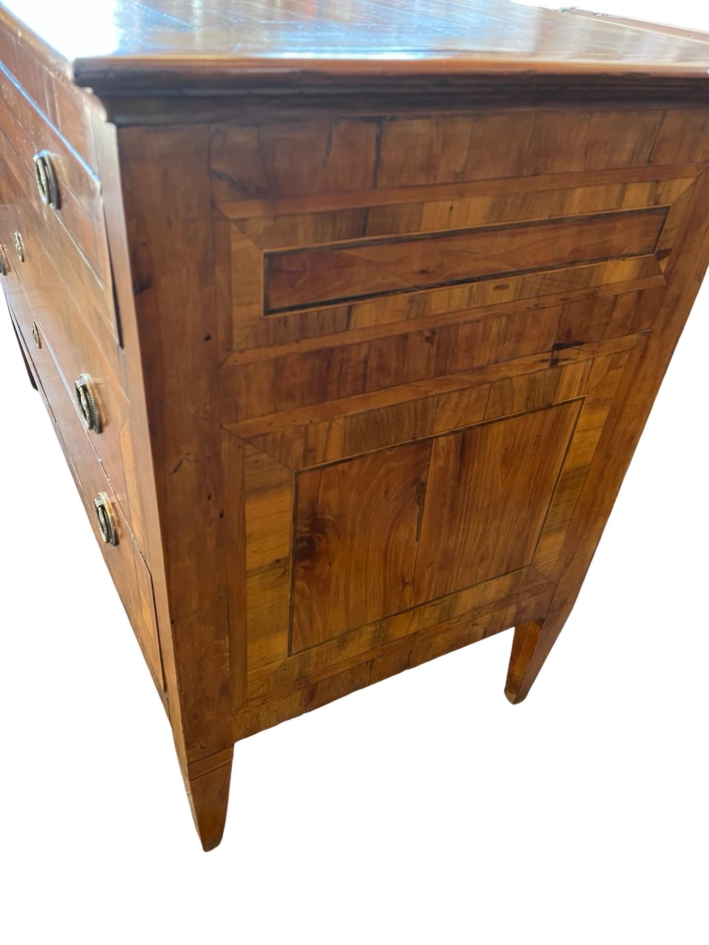 Commode néoclassique fabriquée à la main en Italie à la fin des années 1700 en cerisier et décorée d'un placage de noyer à bandes croisées. La commode comporte trois tiroirs encastrés avec de magnifiques joints à queue d'aronde faits à la main. Les